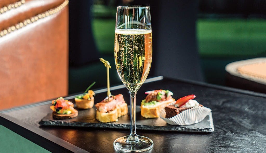 A tray with food and a glass of Catalan region cava champagne, perfect for a celebratory occasion.