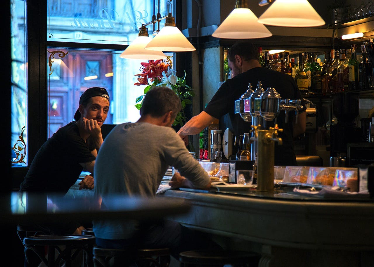 Two individuals enjoying drinks and conversation at a one of Barcelona tapas bars.