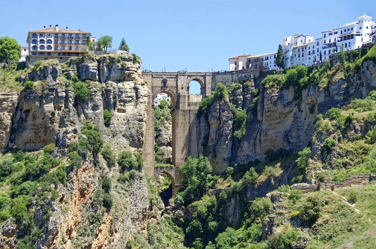 Une vue imprenable sur le pont qui enjambe la gorge de Ronda, à Malaga, mettant en valeur le paysage spectaculaire de la ville.