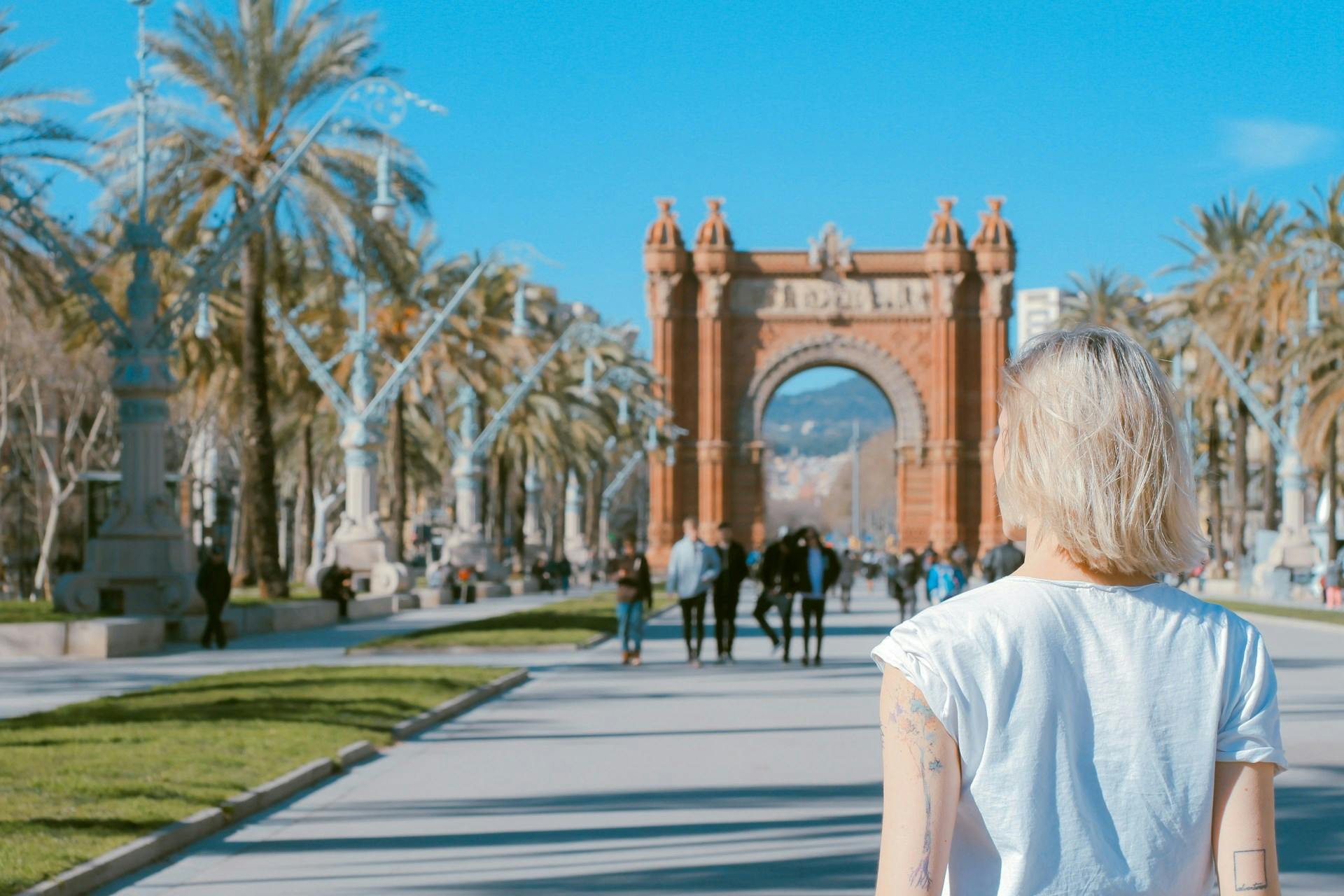 A French girl strolling in Barcelona, with Arc de Triomf in the background.