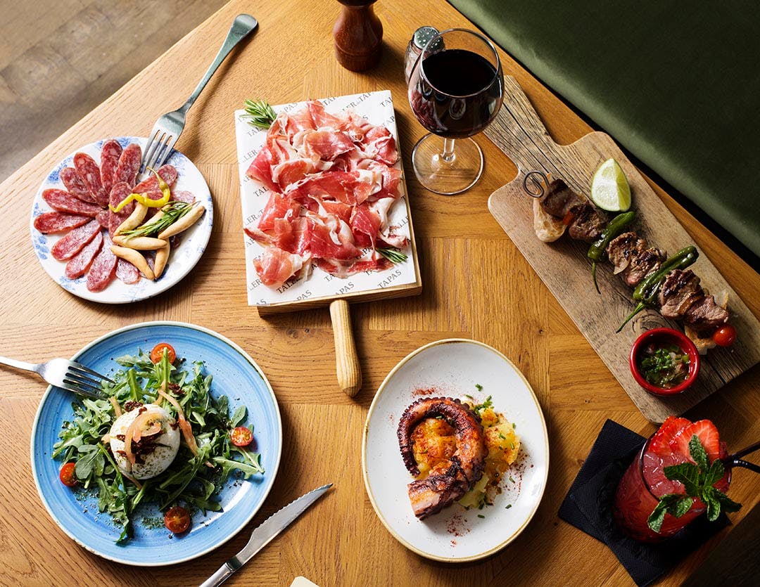 A plate of delicious tapas from Spain served at a cozy restaurant. Various small dishes with different flavors and ingredients.