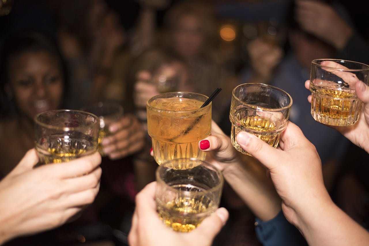 A group of people raising glasses and toasting with drinks, celebrating a special occasion.