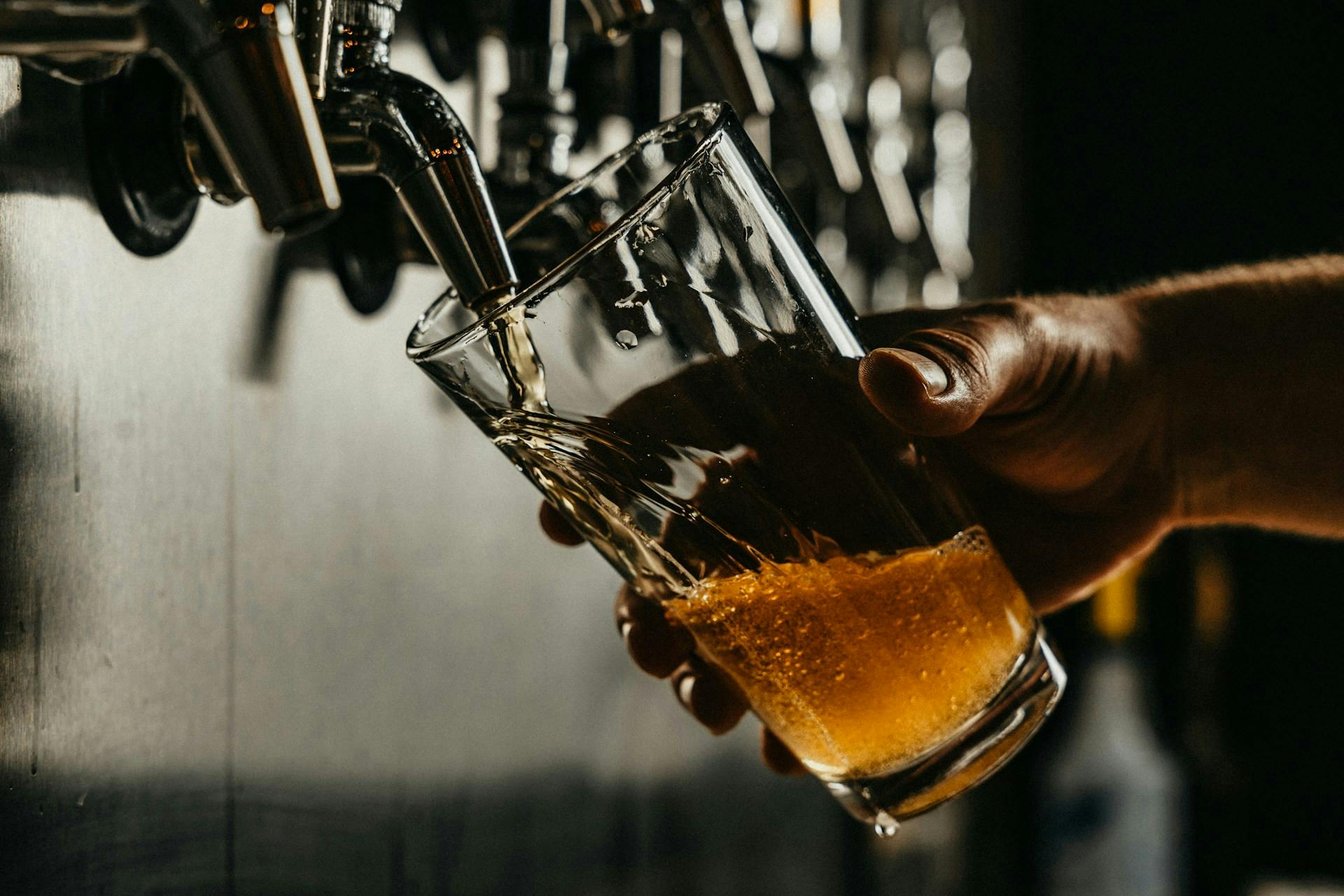 A person holding a glass of beer.