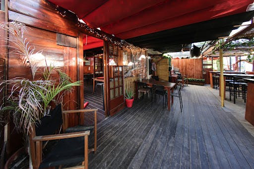 Outdoor dining area with wooden deck, table, and chairs at a restaurant.