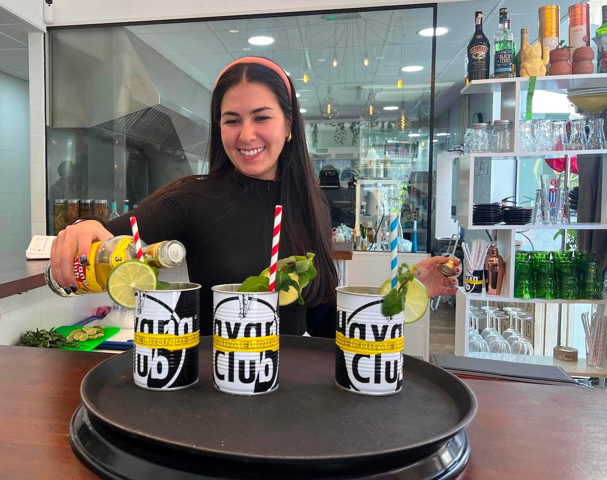 A woman serving two drinks in El Morro restaurant in Salou, Spain.