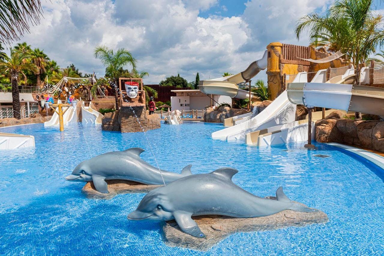 A large pool with dolphins and slides at a hotel in Lloret de Mar.