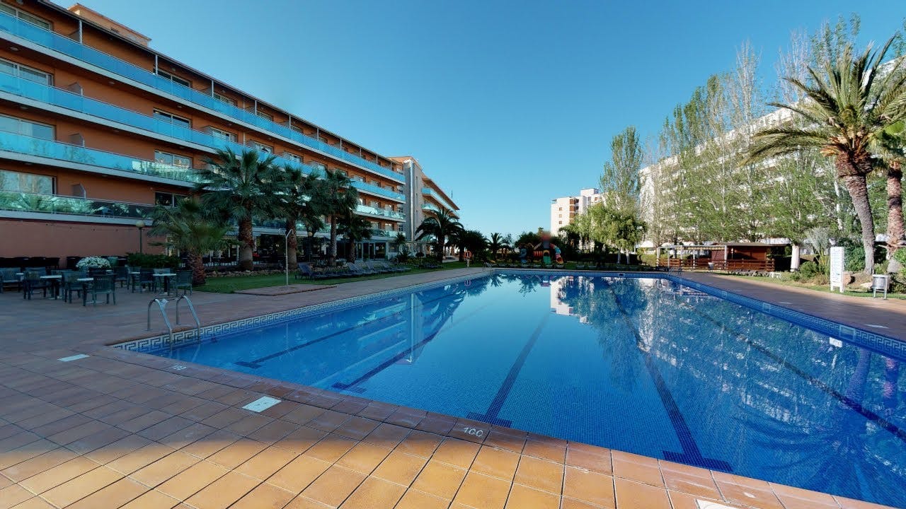 A large swimming pool in front of a building at a hotel in Lloret de Mar.