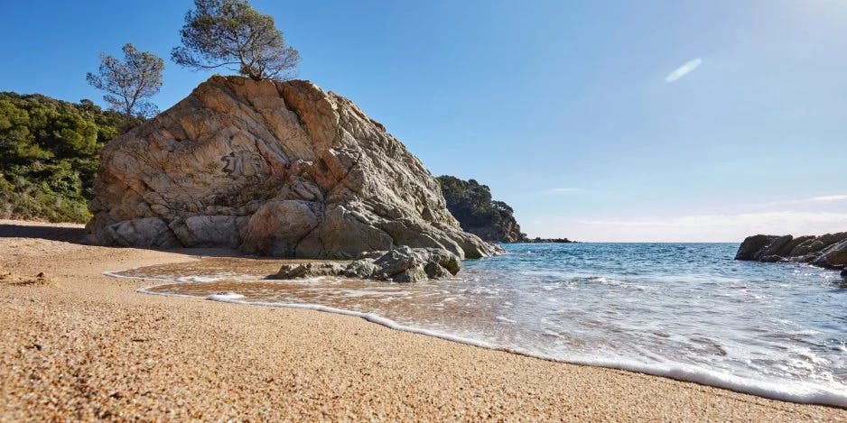 A tranquil beach with a rocky shoreline. 