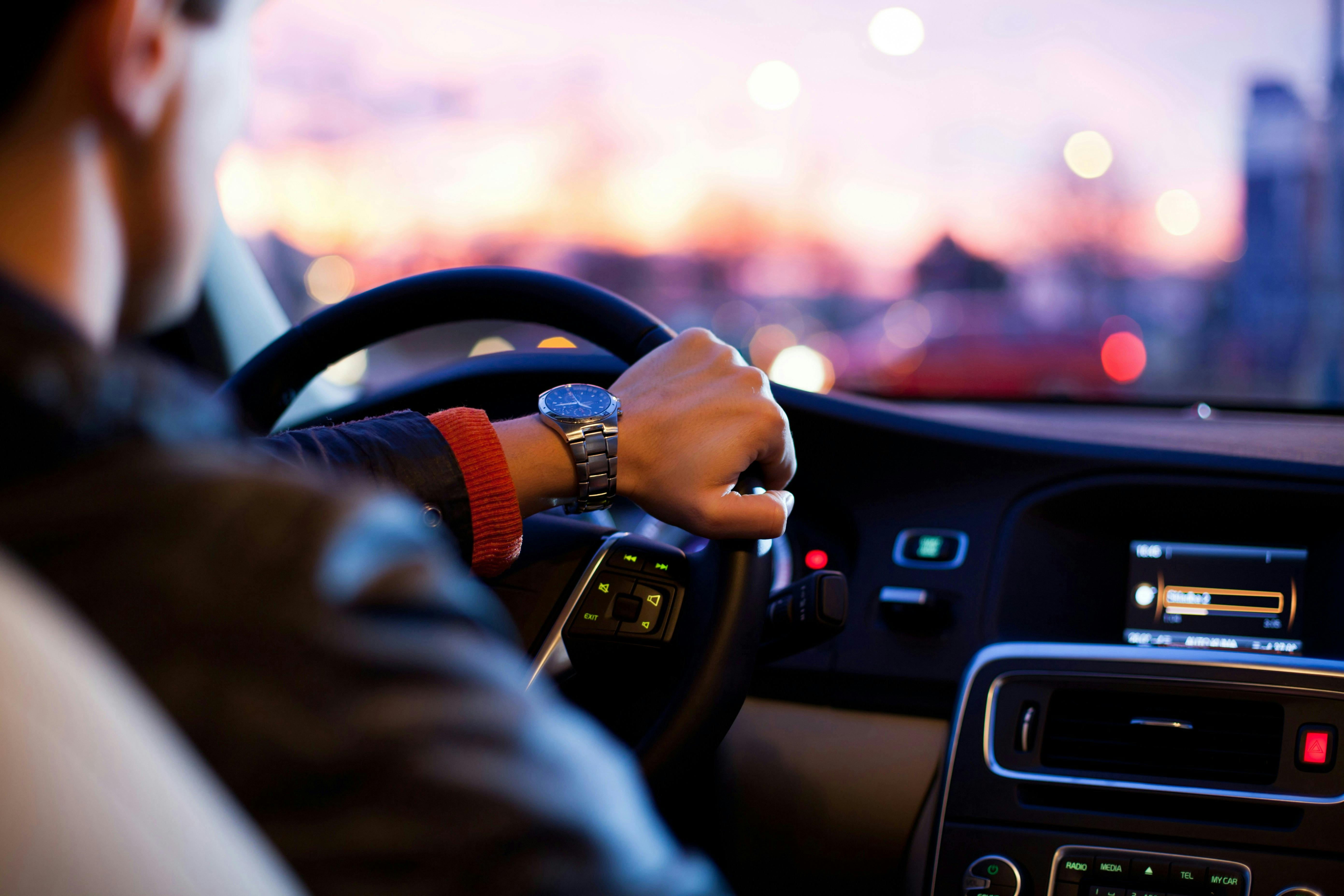 A man is driving a car at night. 