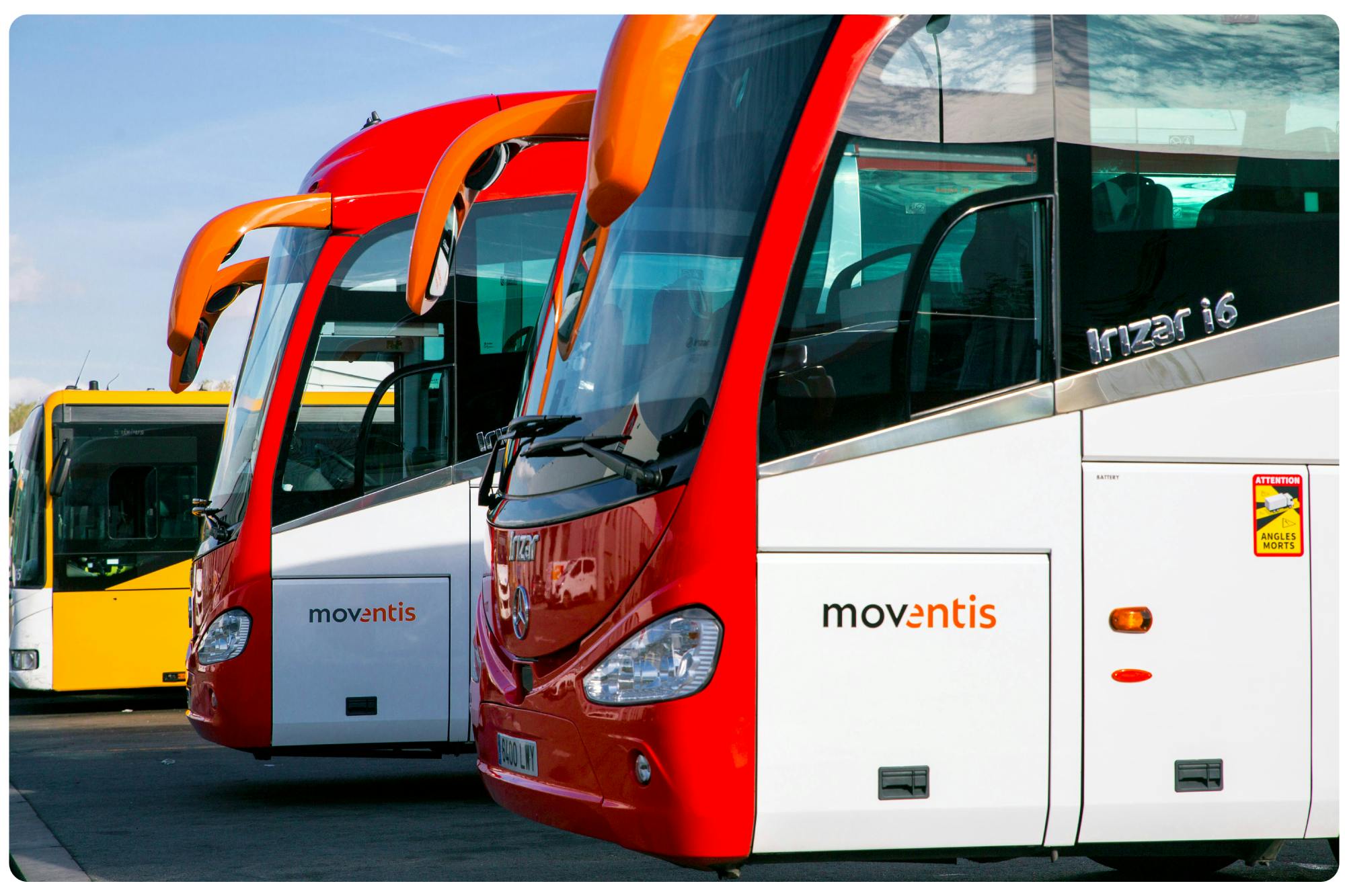 A bus parked neatly in a parking lot.