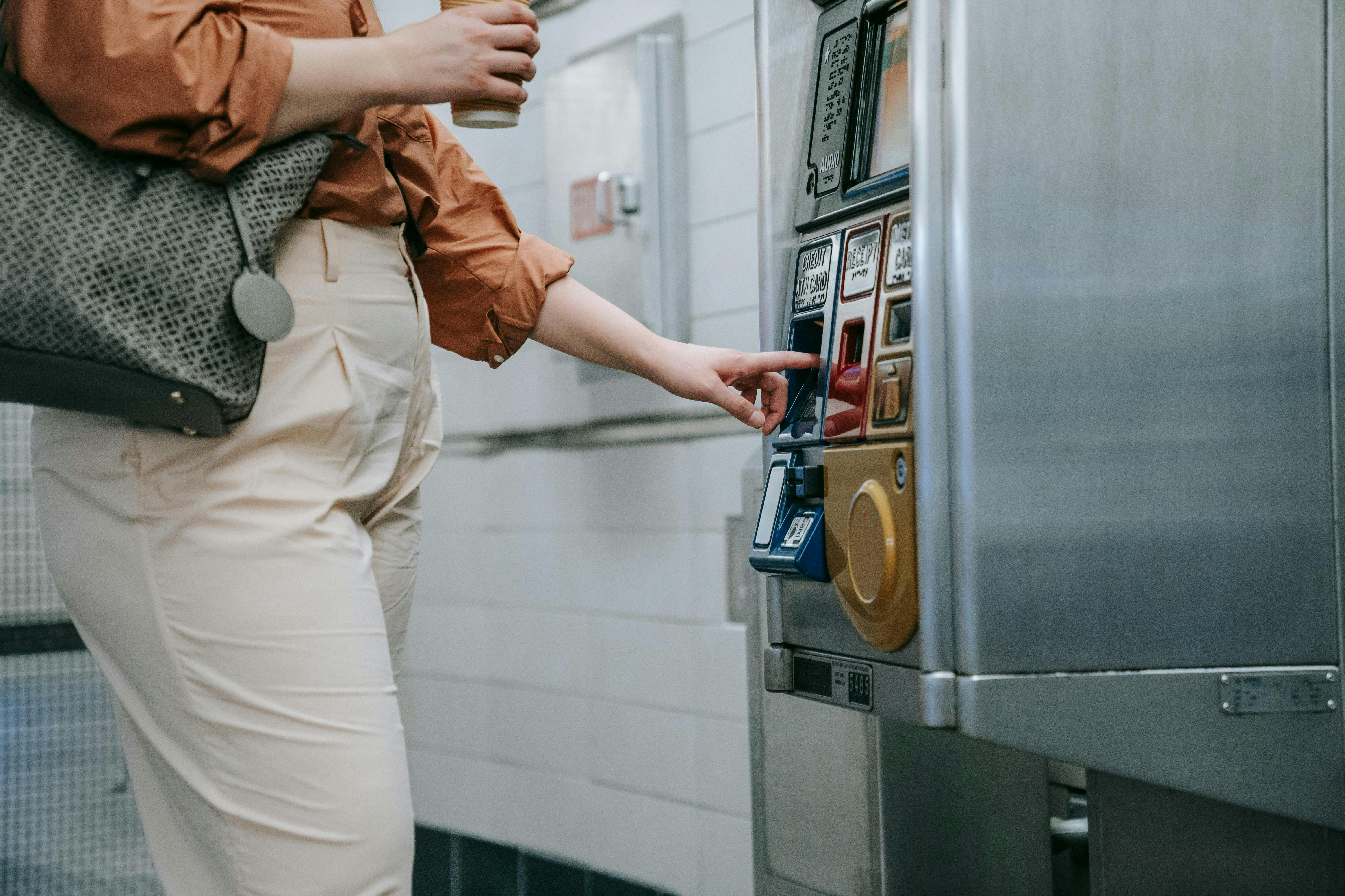 A person using a credit card to buy from a vending machine.