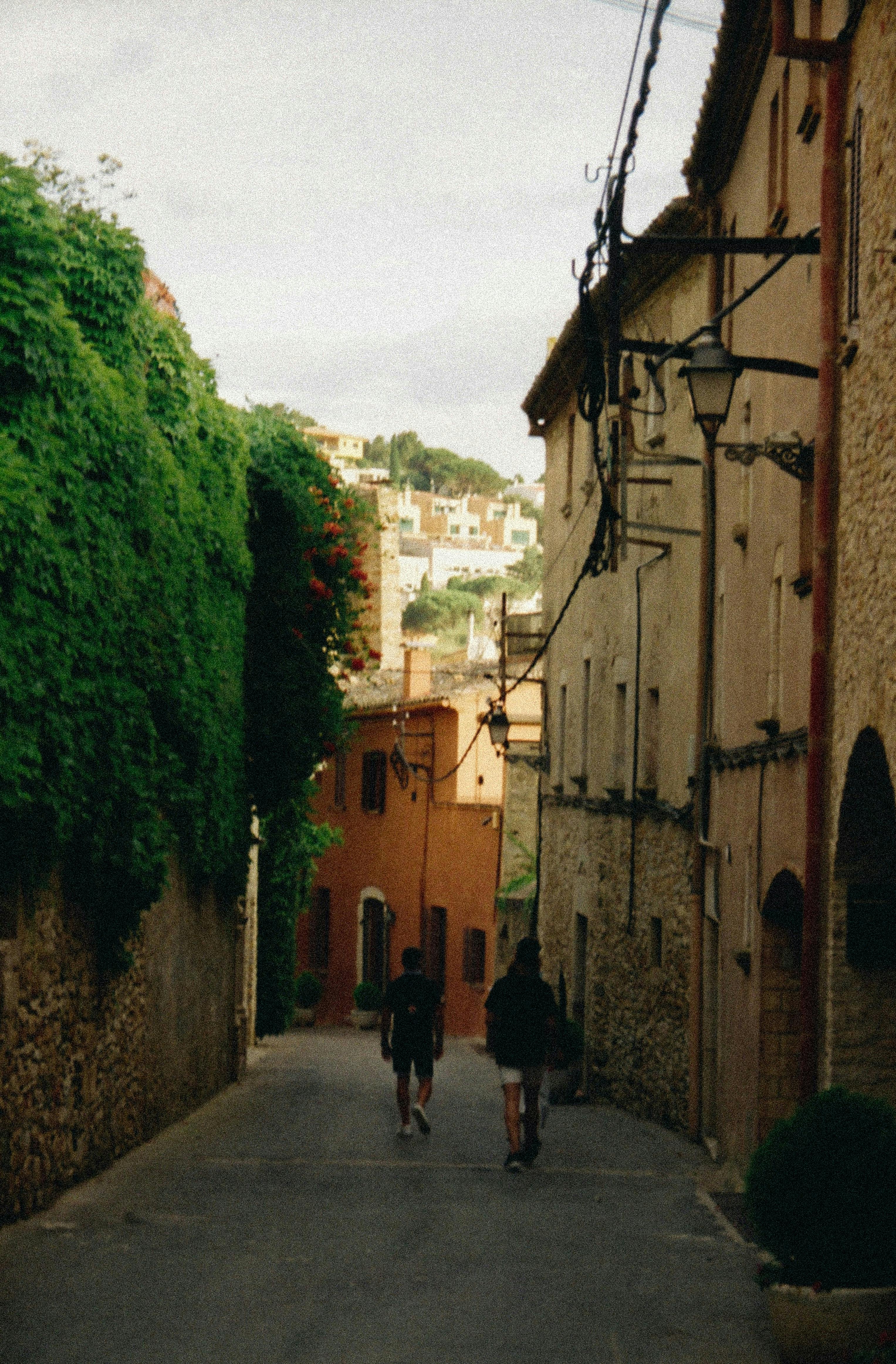 Un couple se promène dans une rue étroite de Begur, Costa Brava.