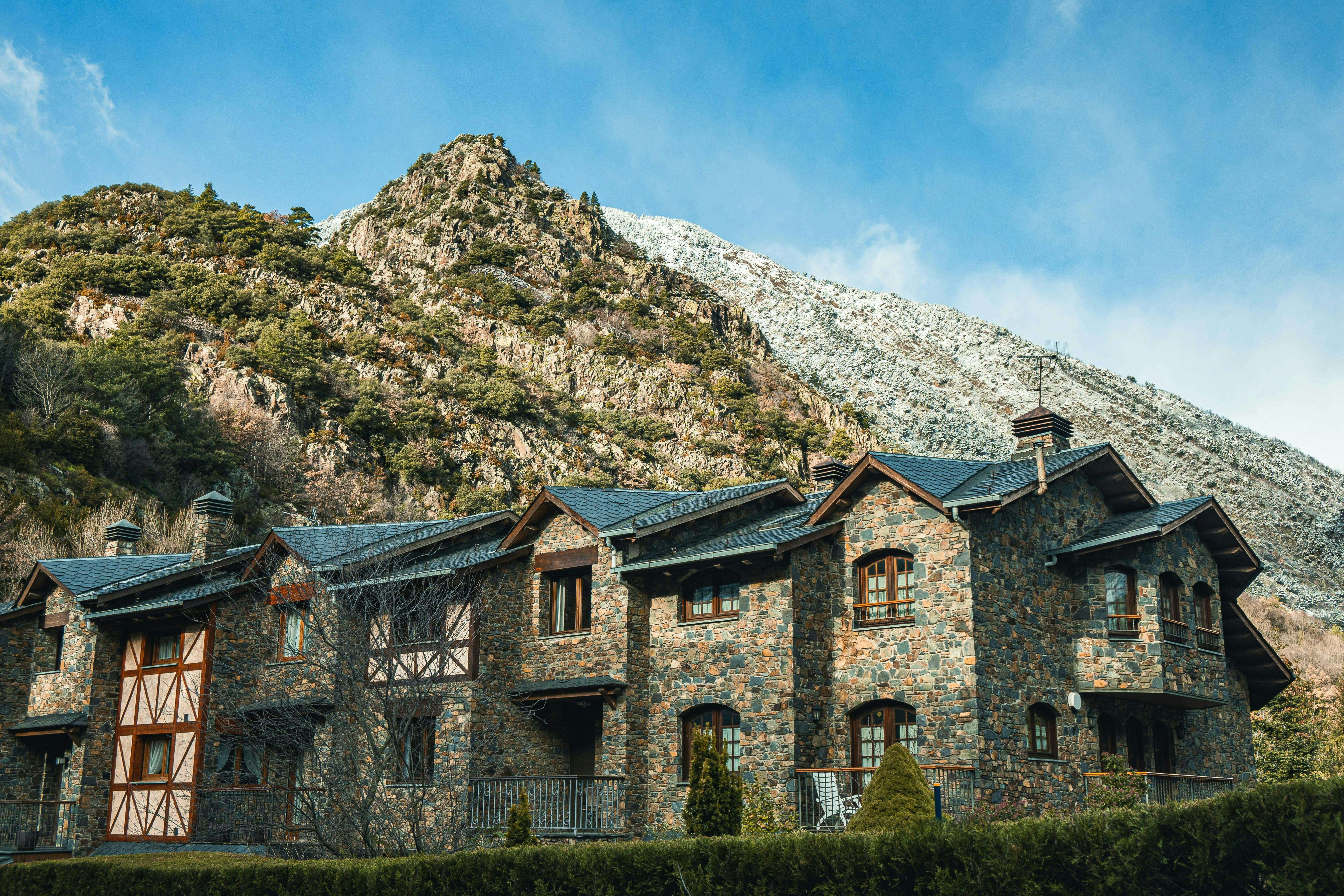 A stone building with a mountain in the background, located in Andorra.