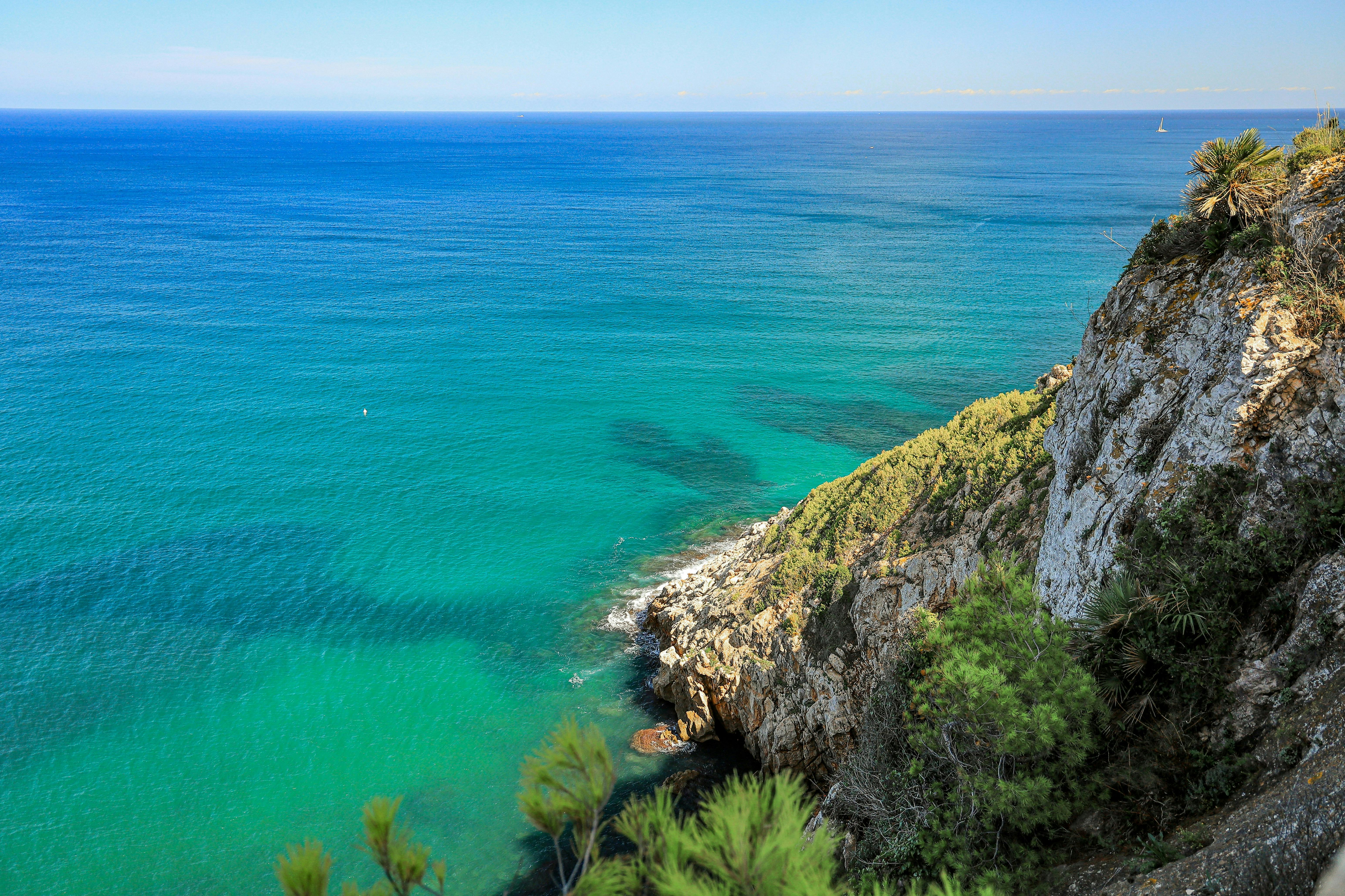 Un paisaje sereno con un lago tranquilo que refleja los coloridos árboles otoñales bajo un cielo azul claro