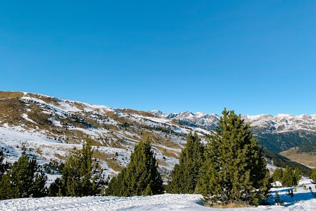 Winter scene of snow-covered mountains and trees in Soldeu, Andorra.