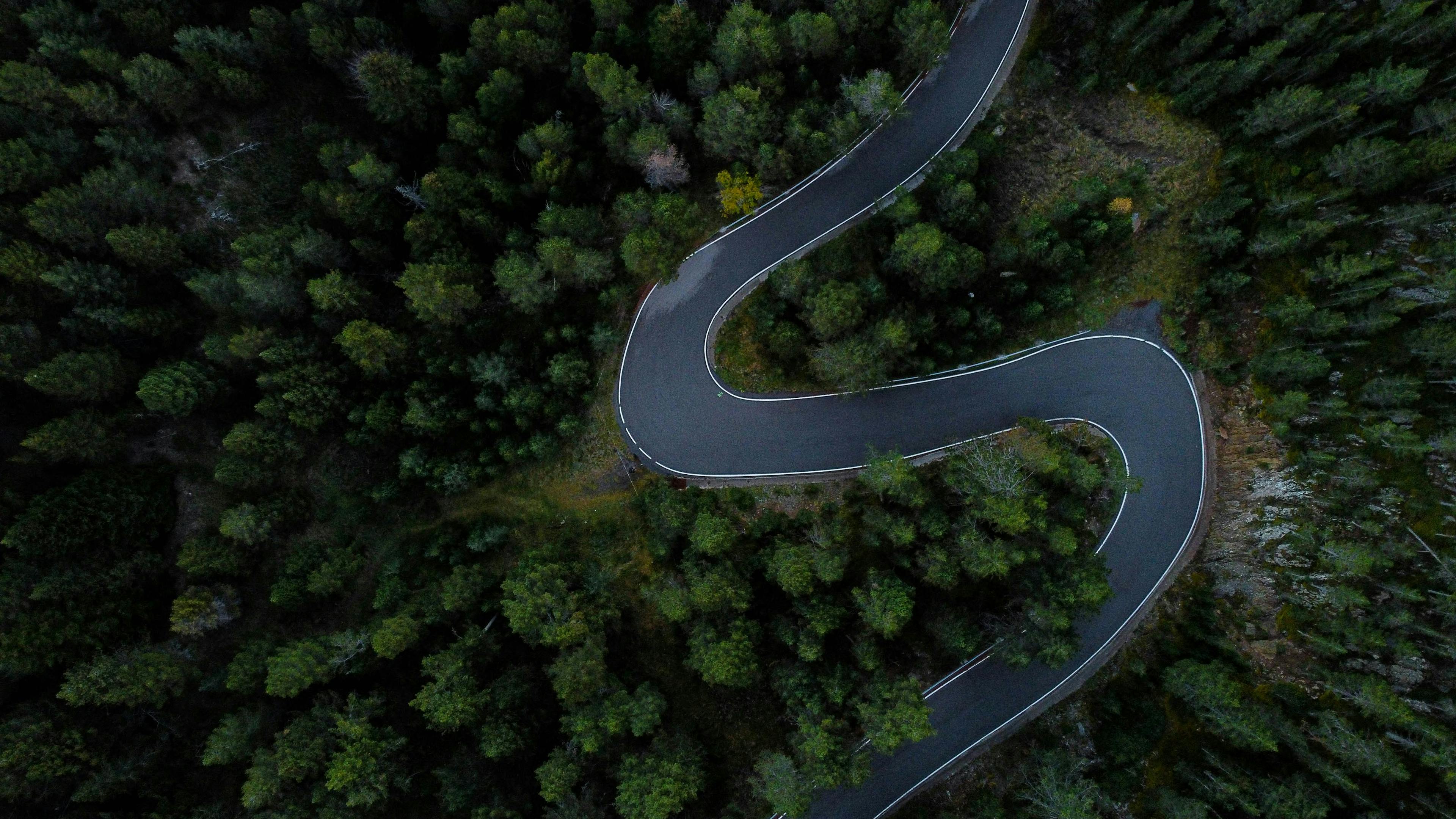 Vue aérienne d'une route sinueuse à travers la forêt en Andorre.