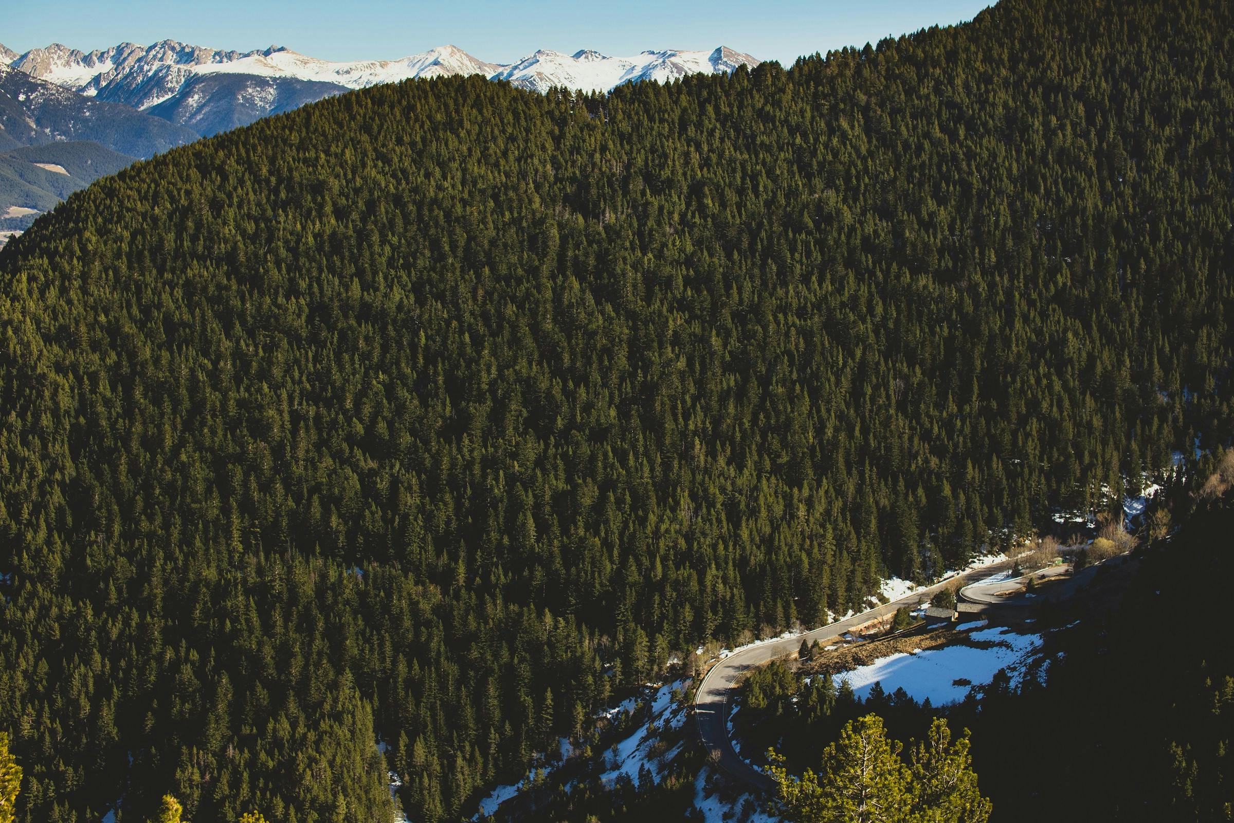 A scenic mountain range in Arinsal, Andorra, with a winding road, offers breathtaking views.