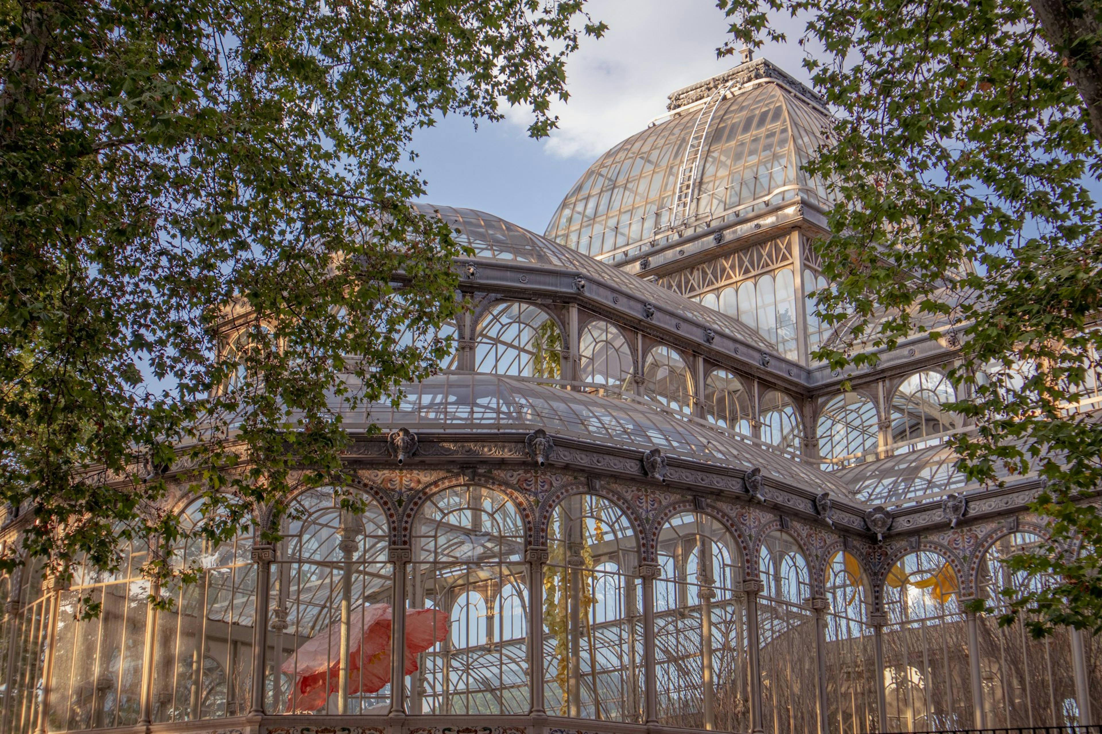 A large building with a large glass roof, known as Palacio de Cristal in Madrid.