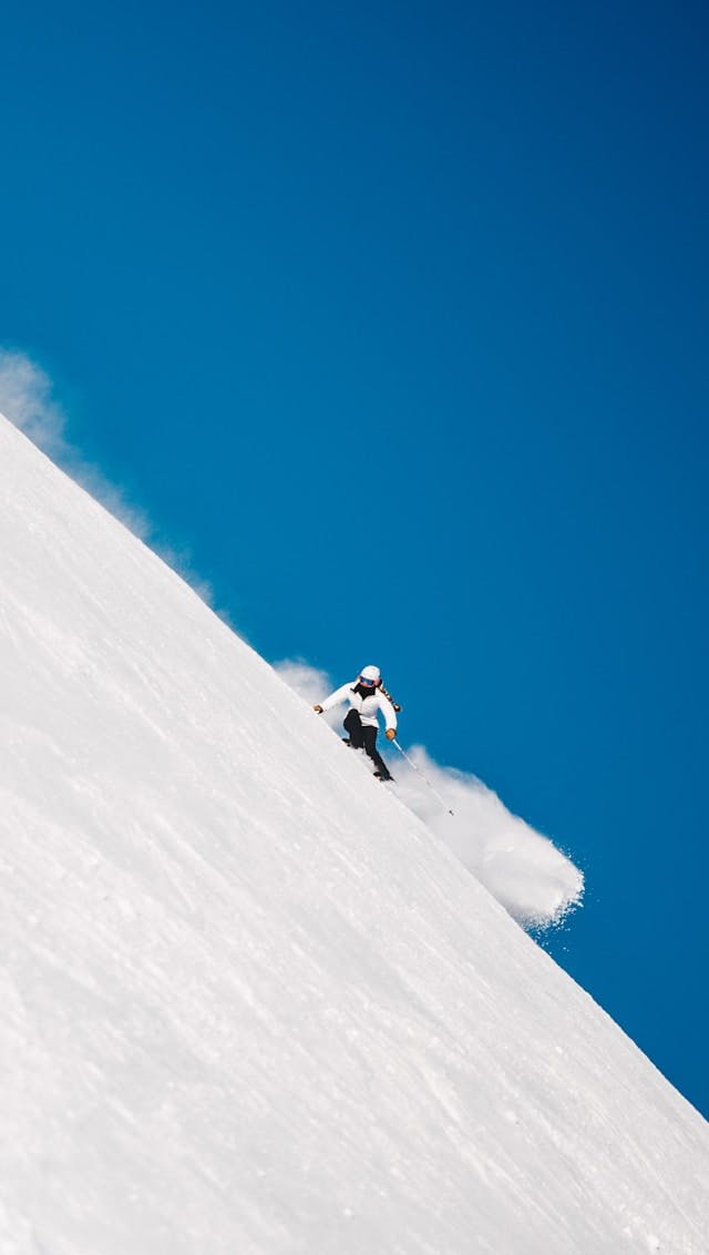 A skier gracefully gliding down a snowy slope.