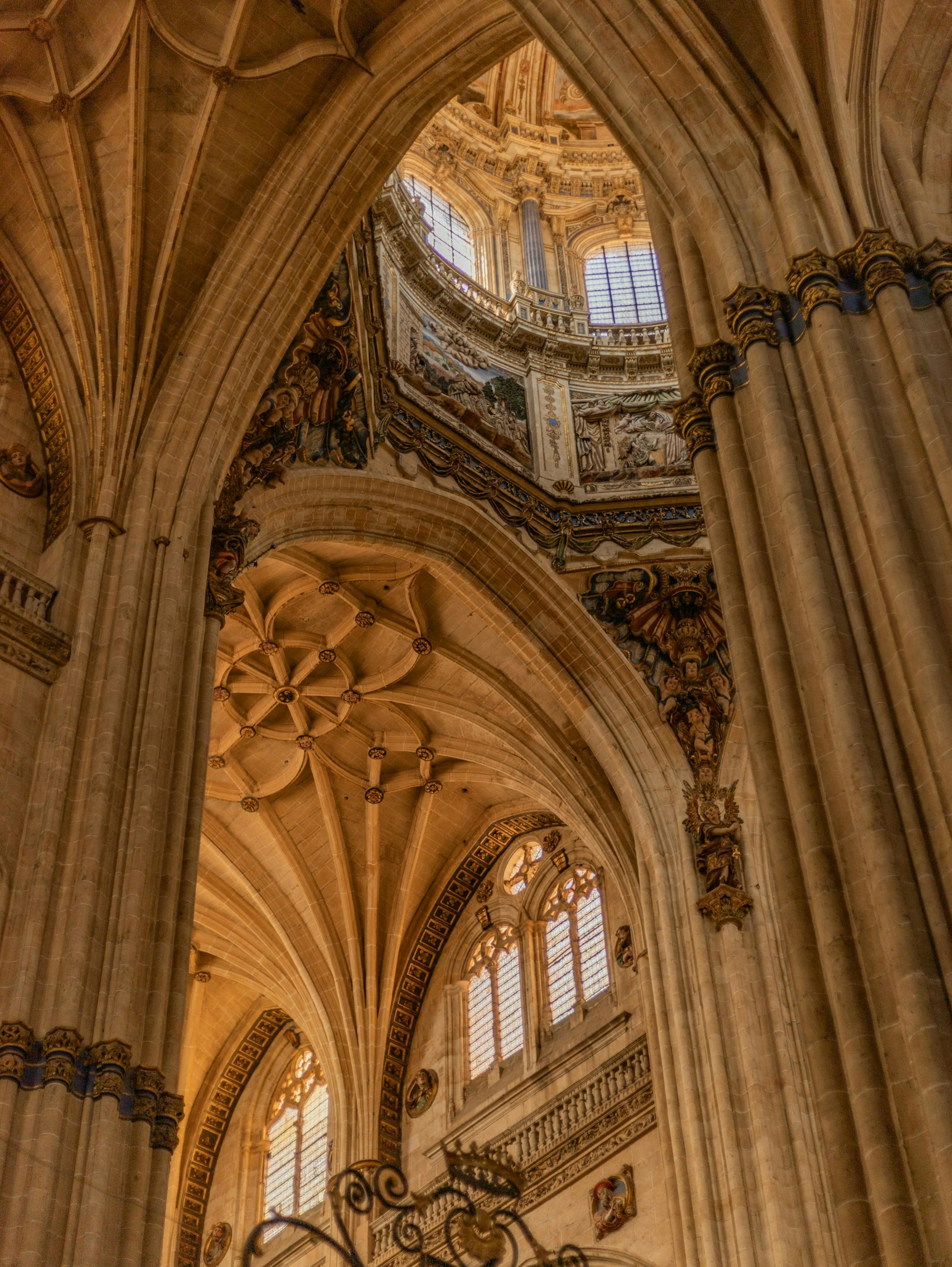 Intérieur de la cathédrale de Salamanque avec son horloge ornée et son plafond complexe.