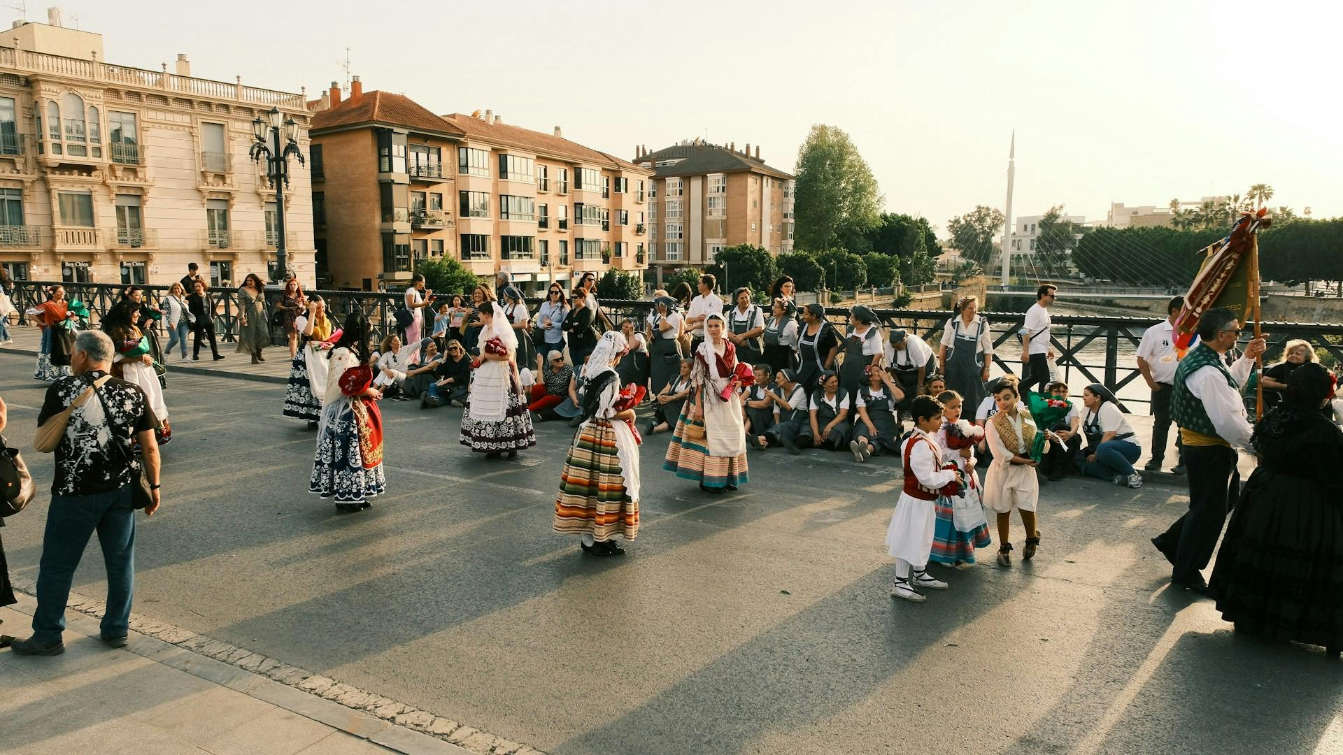 A group of individuals in traditional costumes strolls through the streets of Murcia