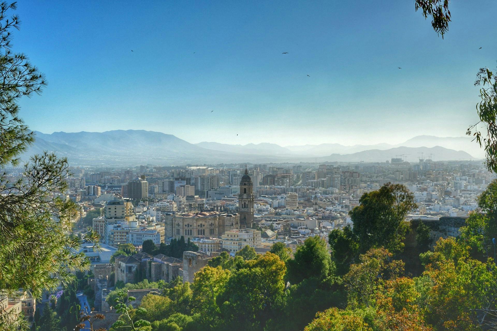 A panoramic view of Malaga from a hilltop, showcasing the city's architecture and landscape.