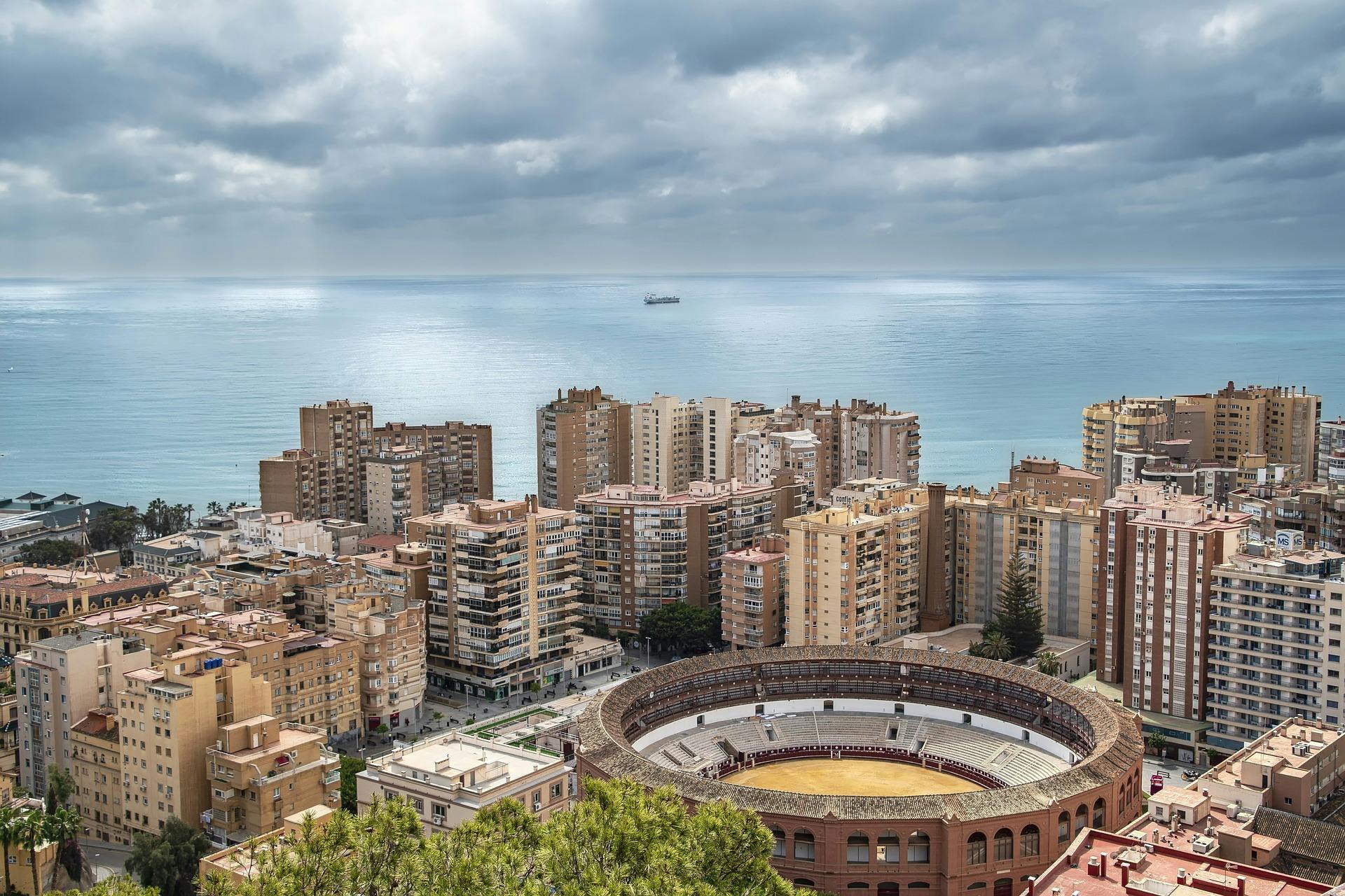 A panoramic view of Malaga, Spain, showcasing its vibrant architecture and coastal scenery under a clear blue sky.