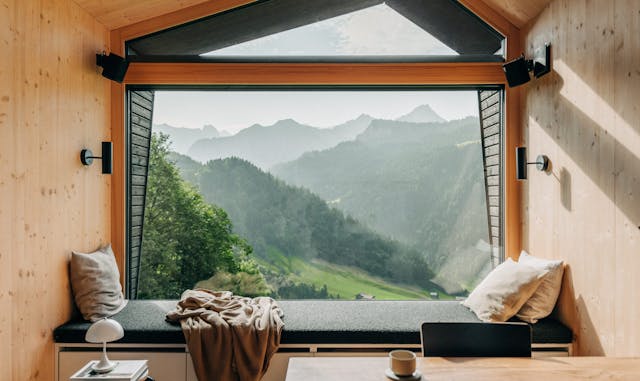 Innansicht aus einer Cabin hinaus auf die Berglandschaft