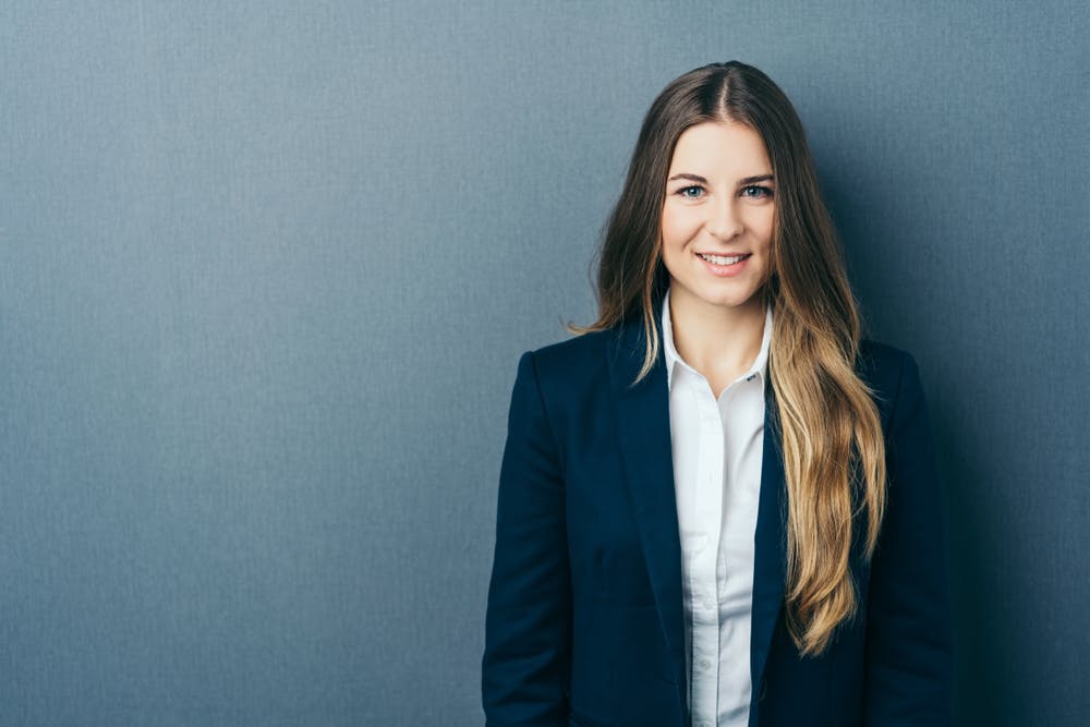 Jeune femme en tailleur pantalon avec une chemise blanche