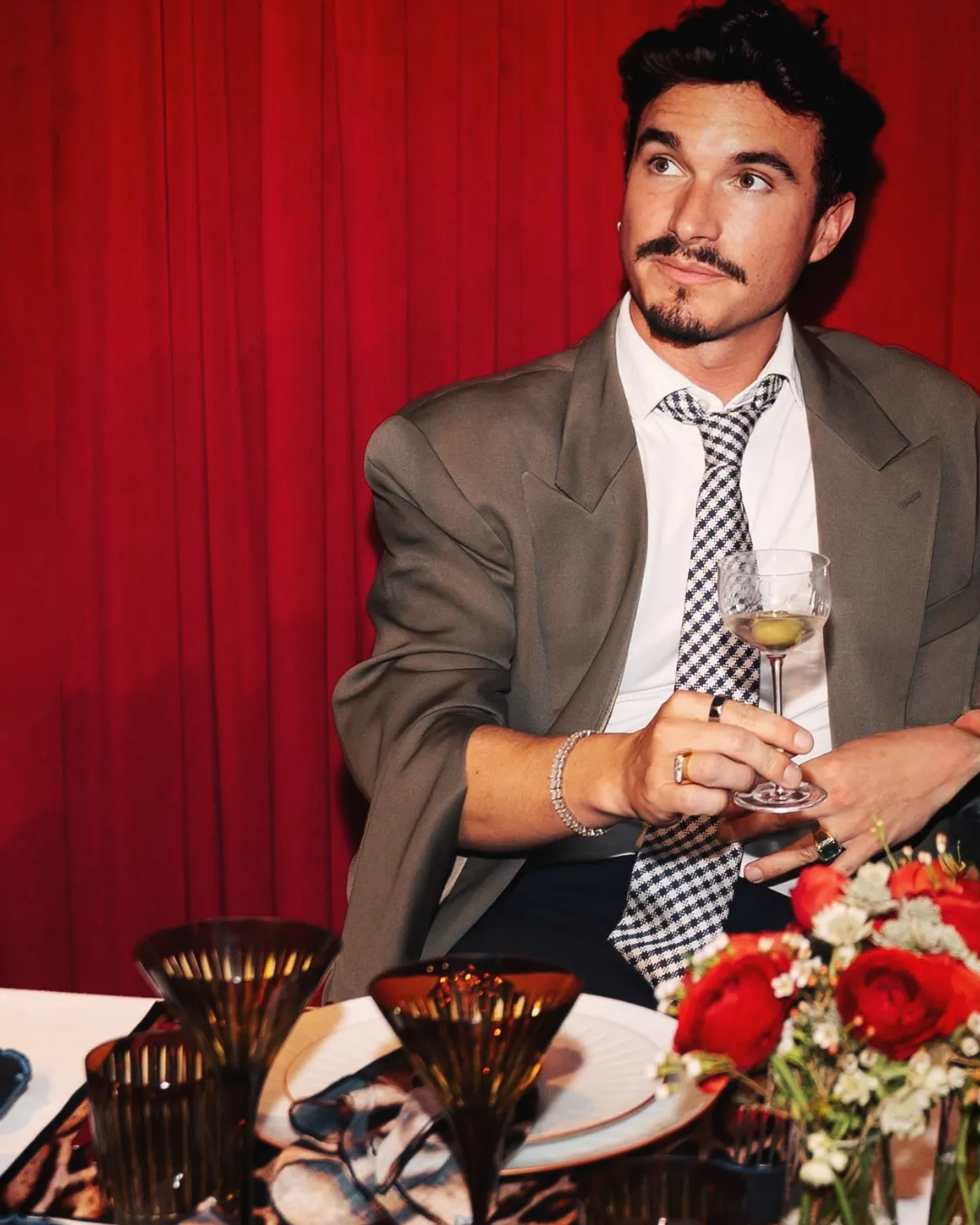 ALEXANDRE DONZÉ SOLIS enjoying a cocktail at Café Boulud at Maison Barnes in New York City, seated against the restaurant’s signature red interior.