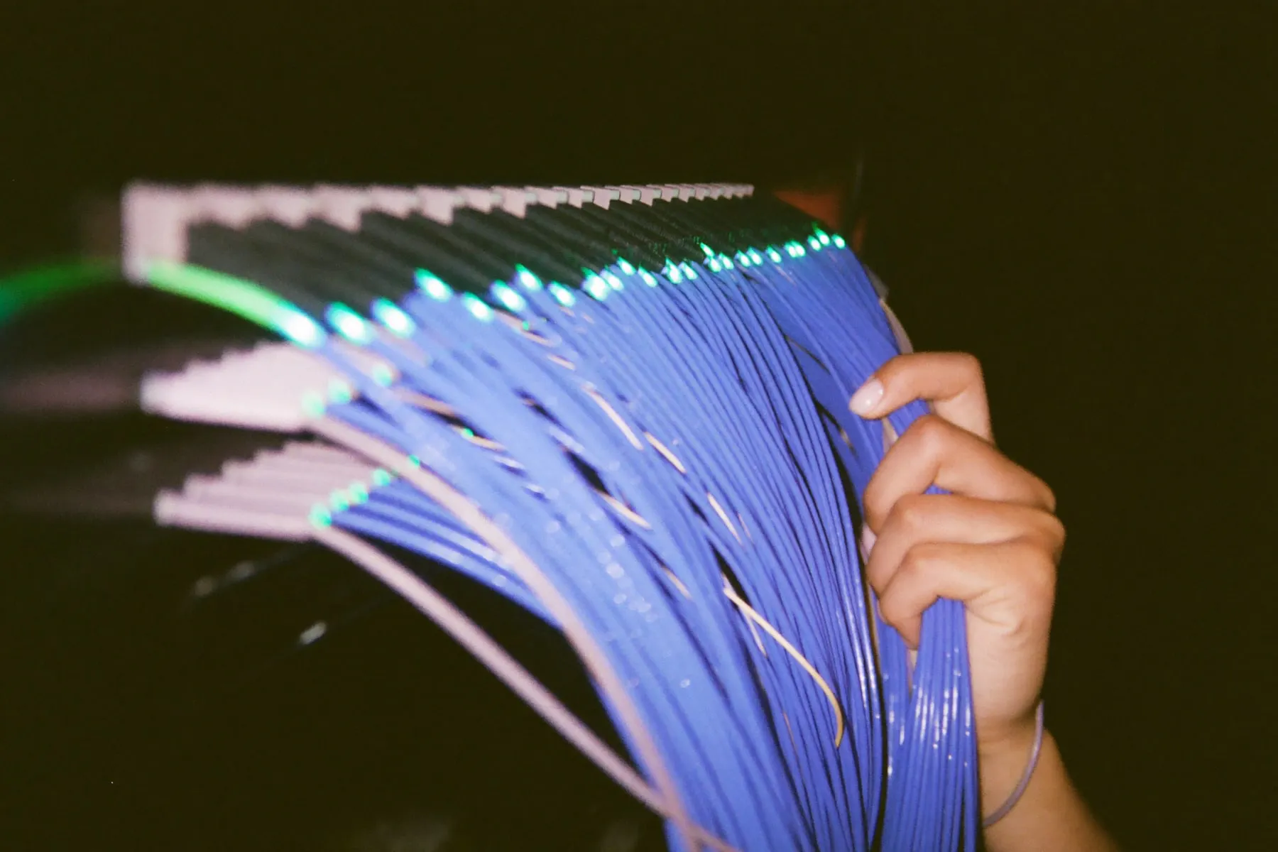 Status lights on server racks stretched into long lines of light by a slow shutter