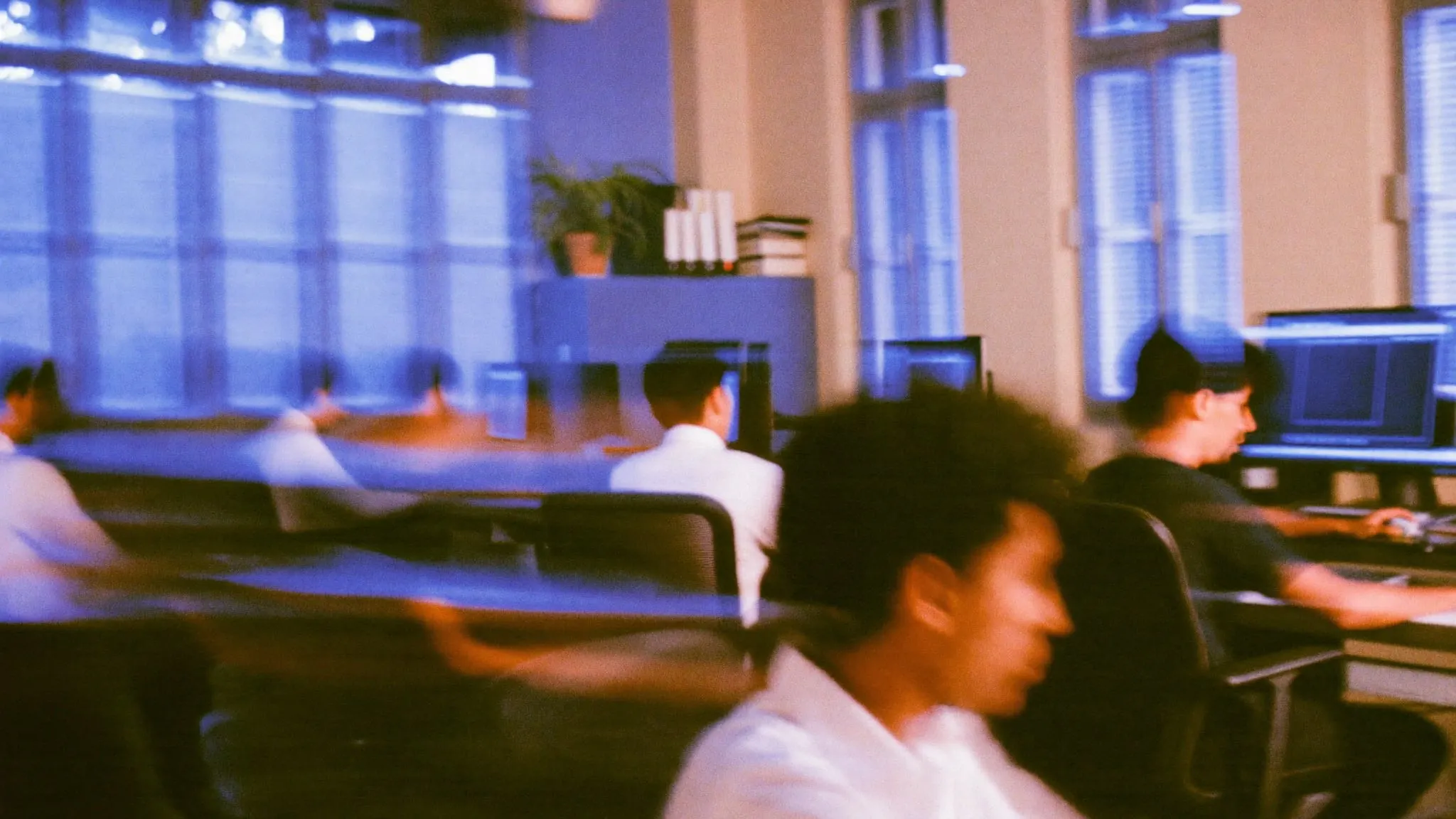 People moving through an office in an old downtown Cairo apartment with tall shuttered windows