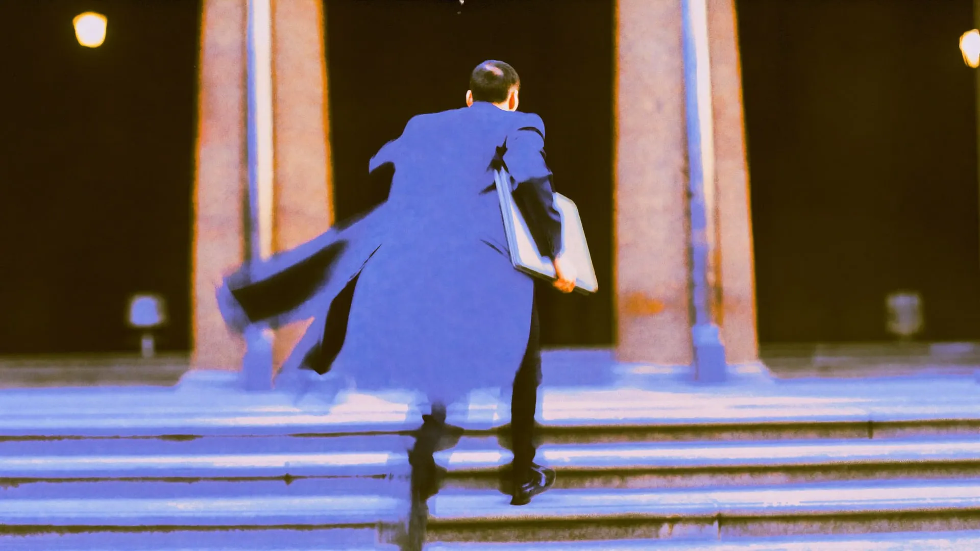 A young lawyer in a dark suit running up the stone steps of a Cairo courthouse at dusk, blurred by a slow shutter.