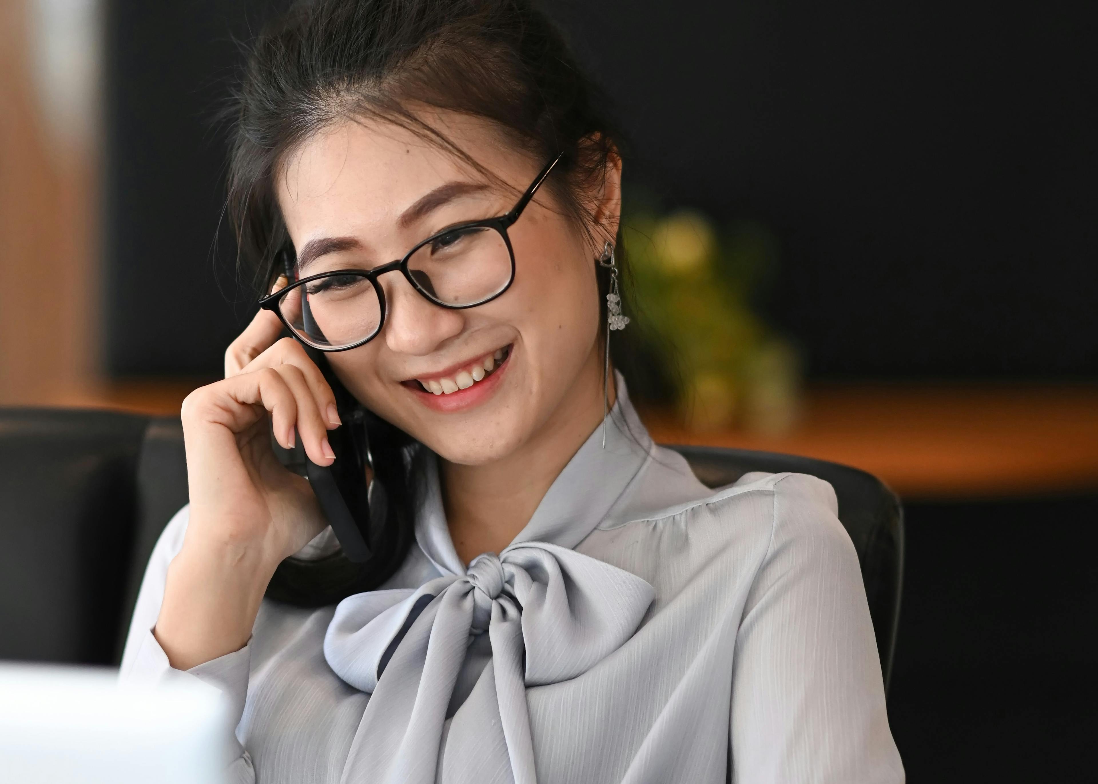 A business woman on a call at her desk