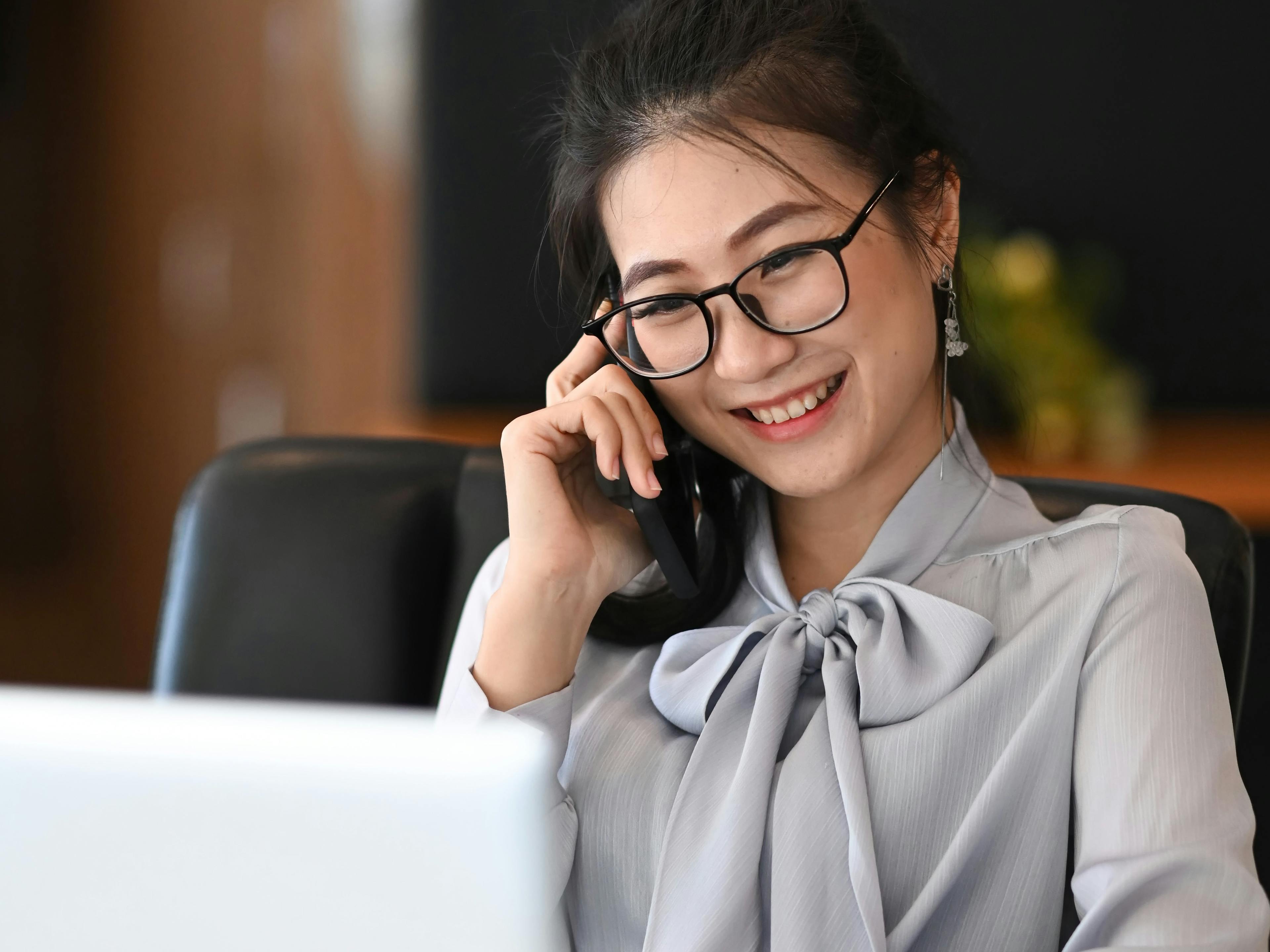 A business woman on a call at her desk