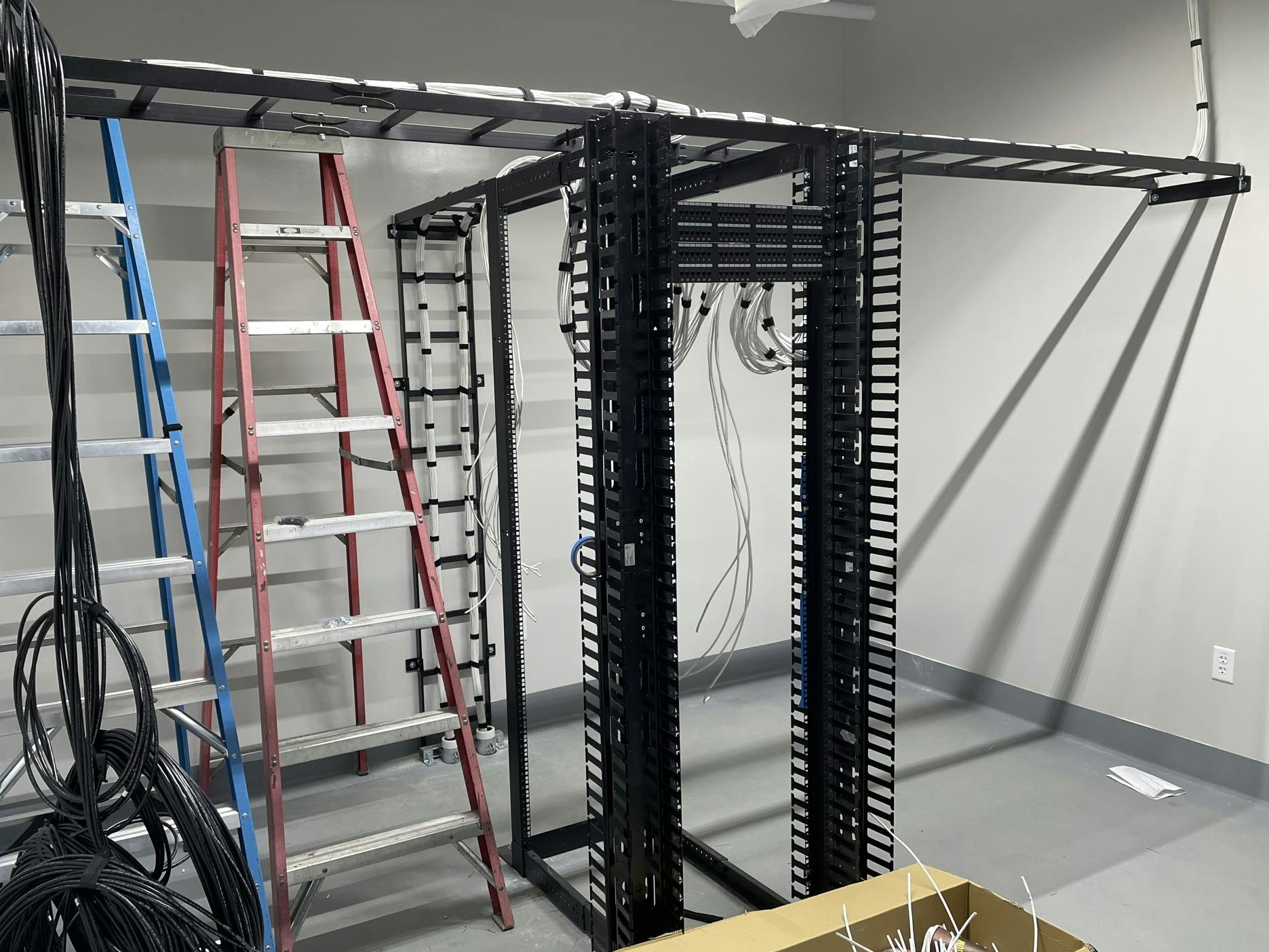 cables and a server rack cabled and ready for equipment to be installed