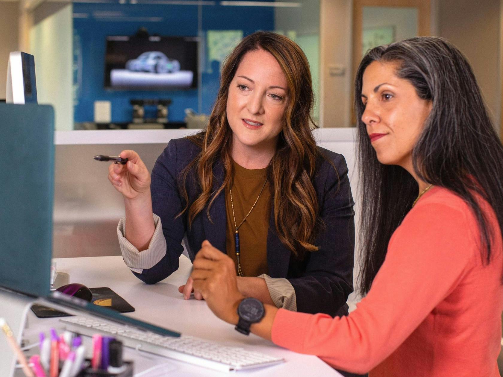 two woman in a business meeting reviewing a computer screen