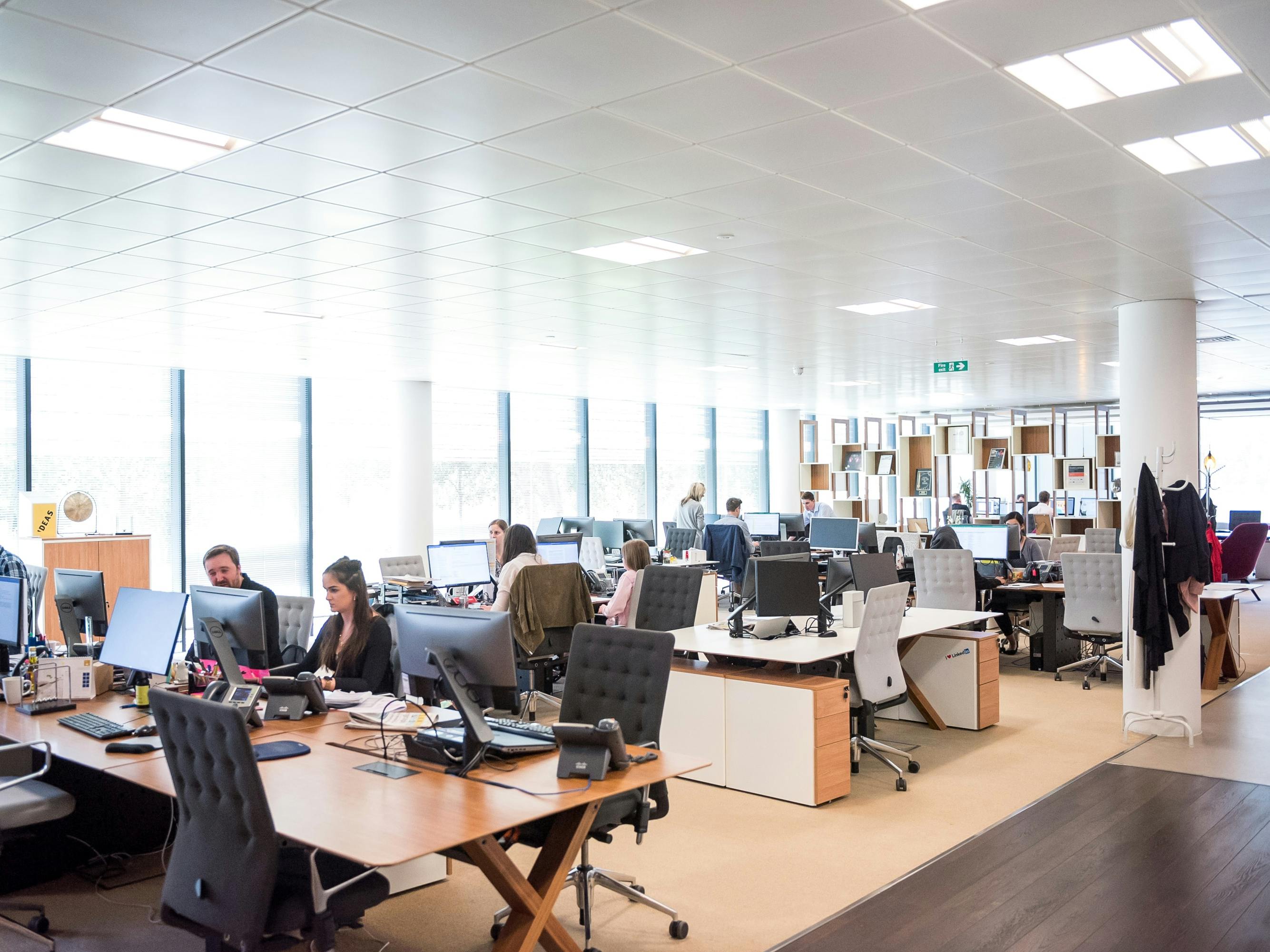 a busy office with many people on phones and computers