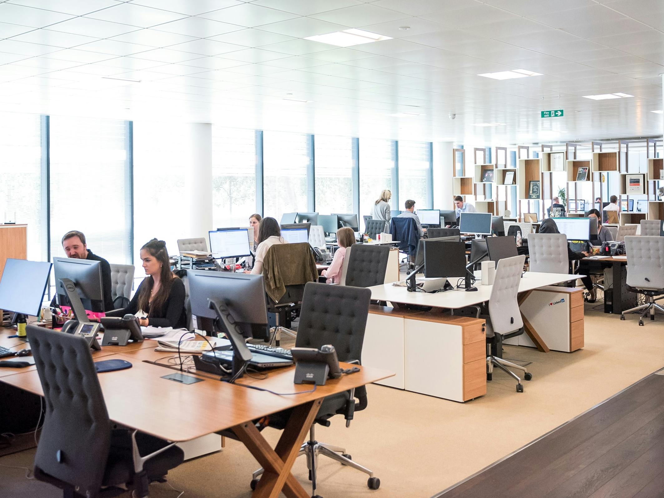 a busy office with many people on phones and computers