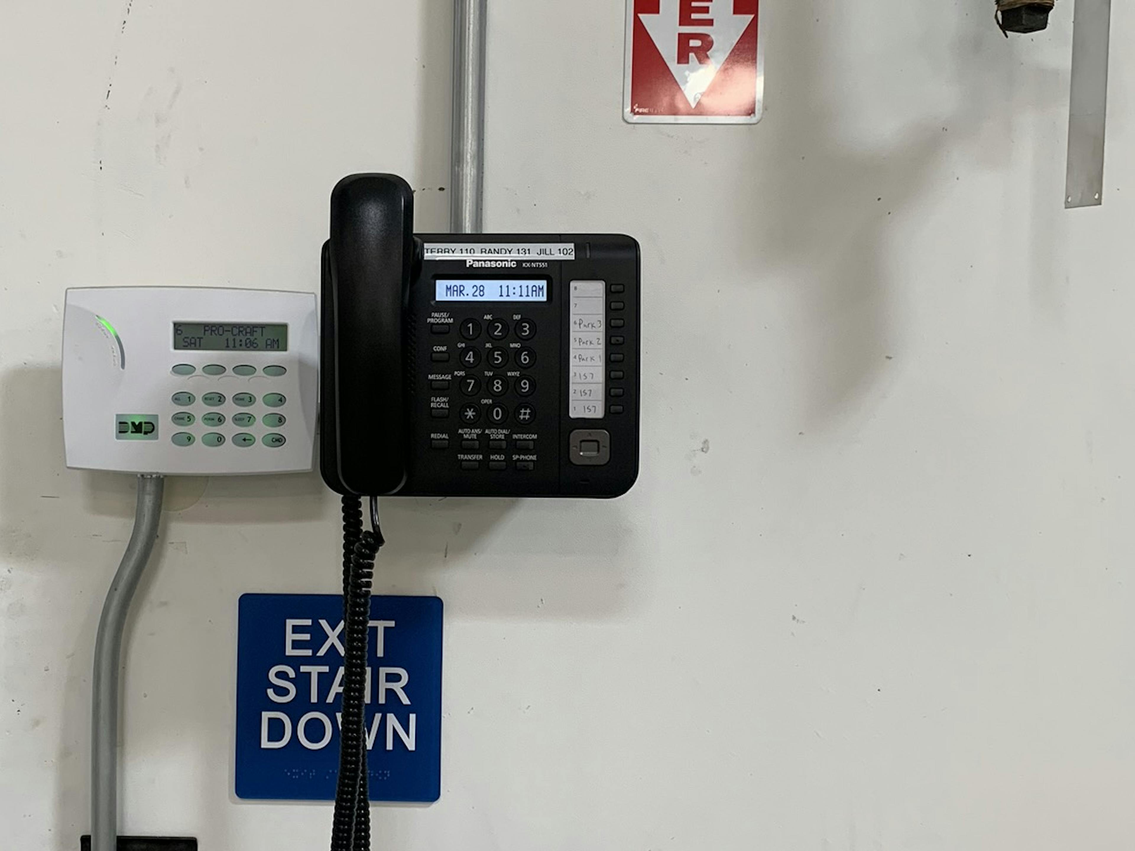 a wall-mounted VoIP phone in a warehouse