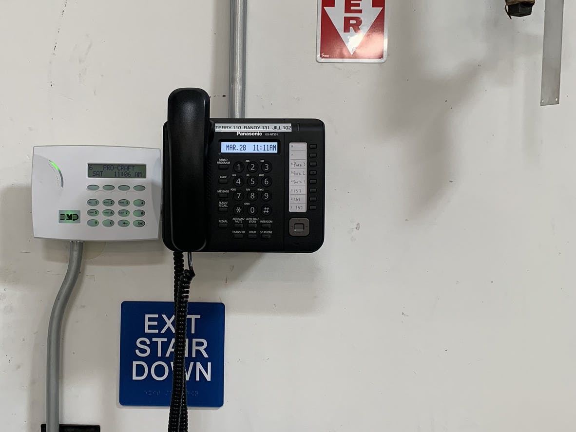 a wall-mounted VoIP phone in a warehouse