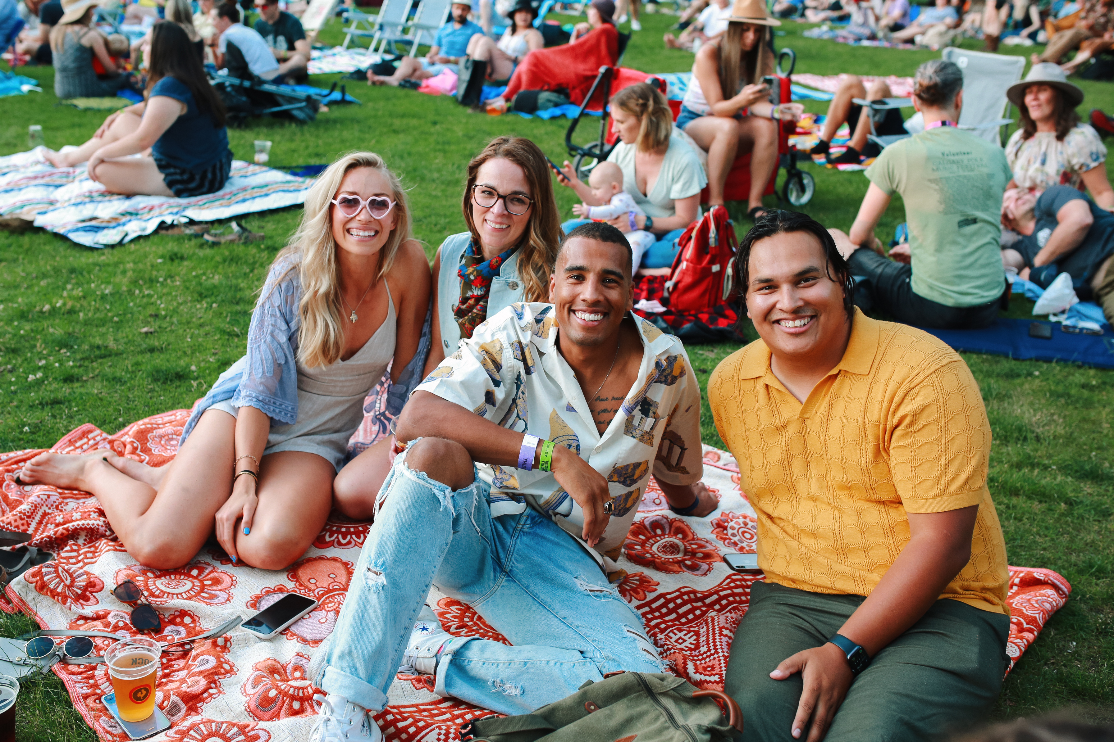Calgary Folk Music Festival attendees smile on a blanket.
