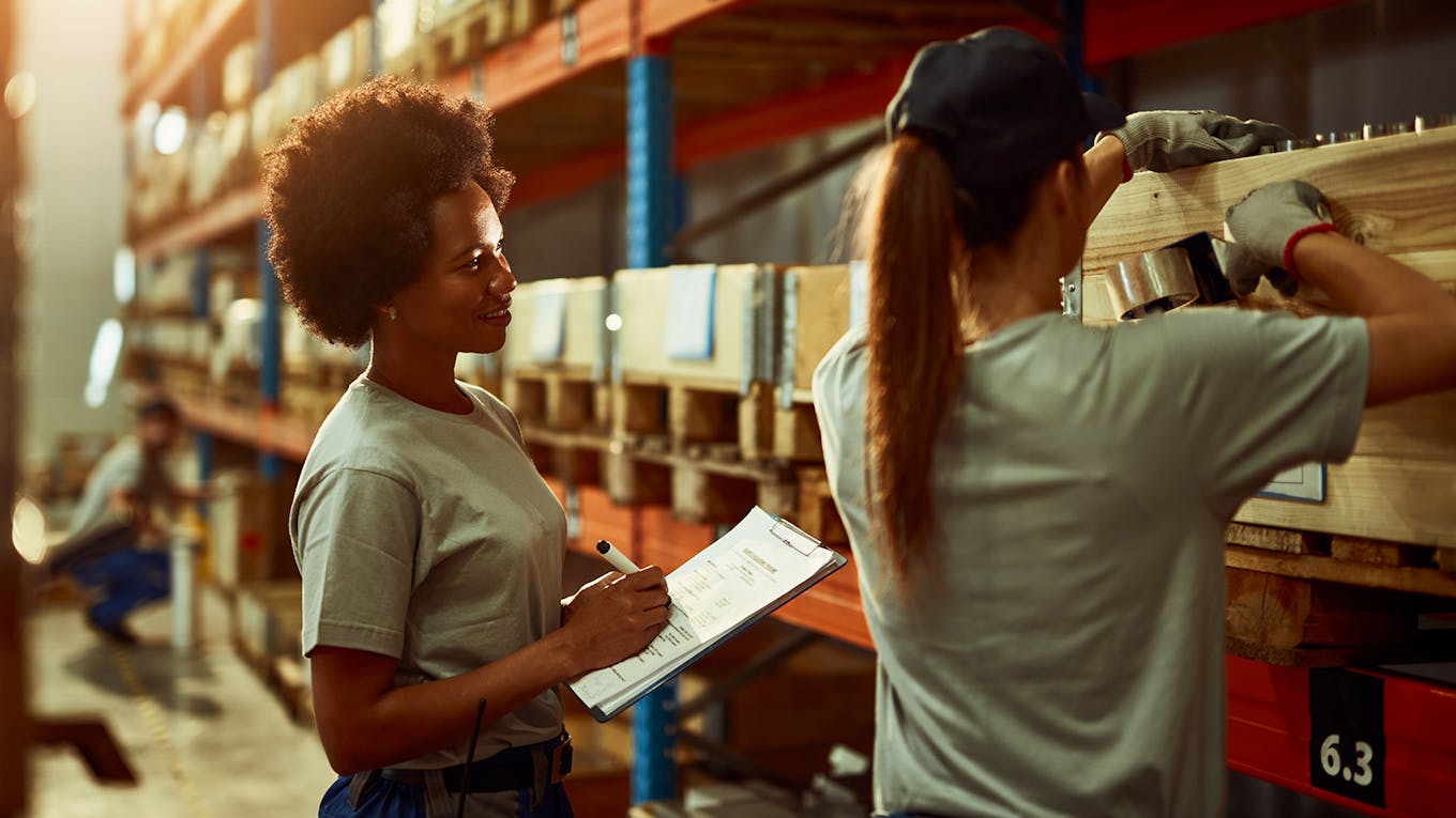 Two Transportation & Logistics workers in a warehouse. 