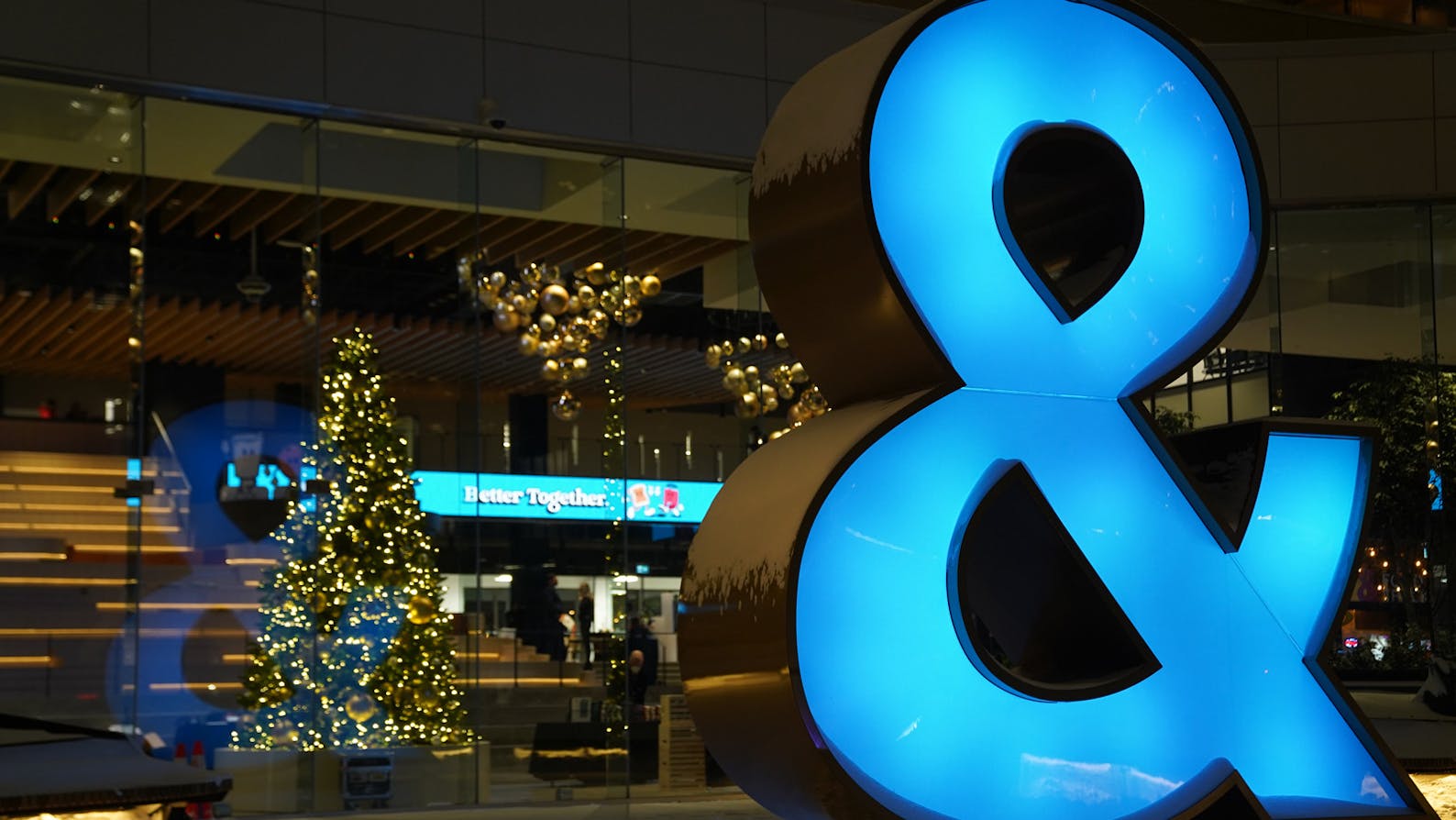 Large blue Ampersand outside the lobby of the Ampersand building, decorated for the holidays