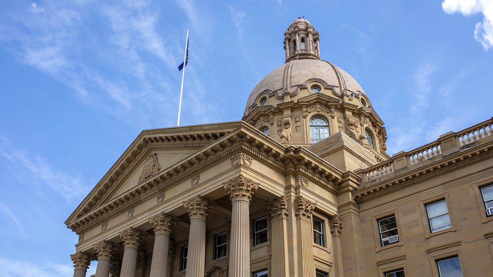 Alberta Legislature Building in front of blue sky from downward angle