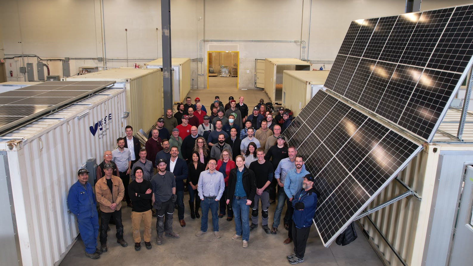 The Westgen team beside a solar panel.