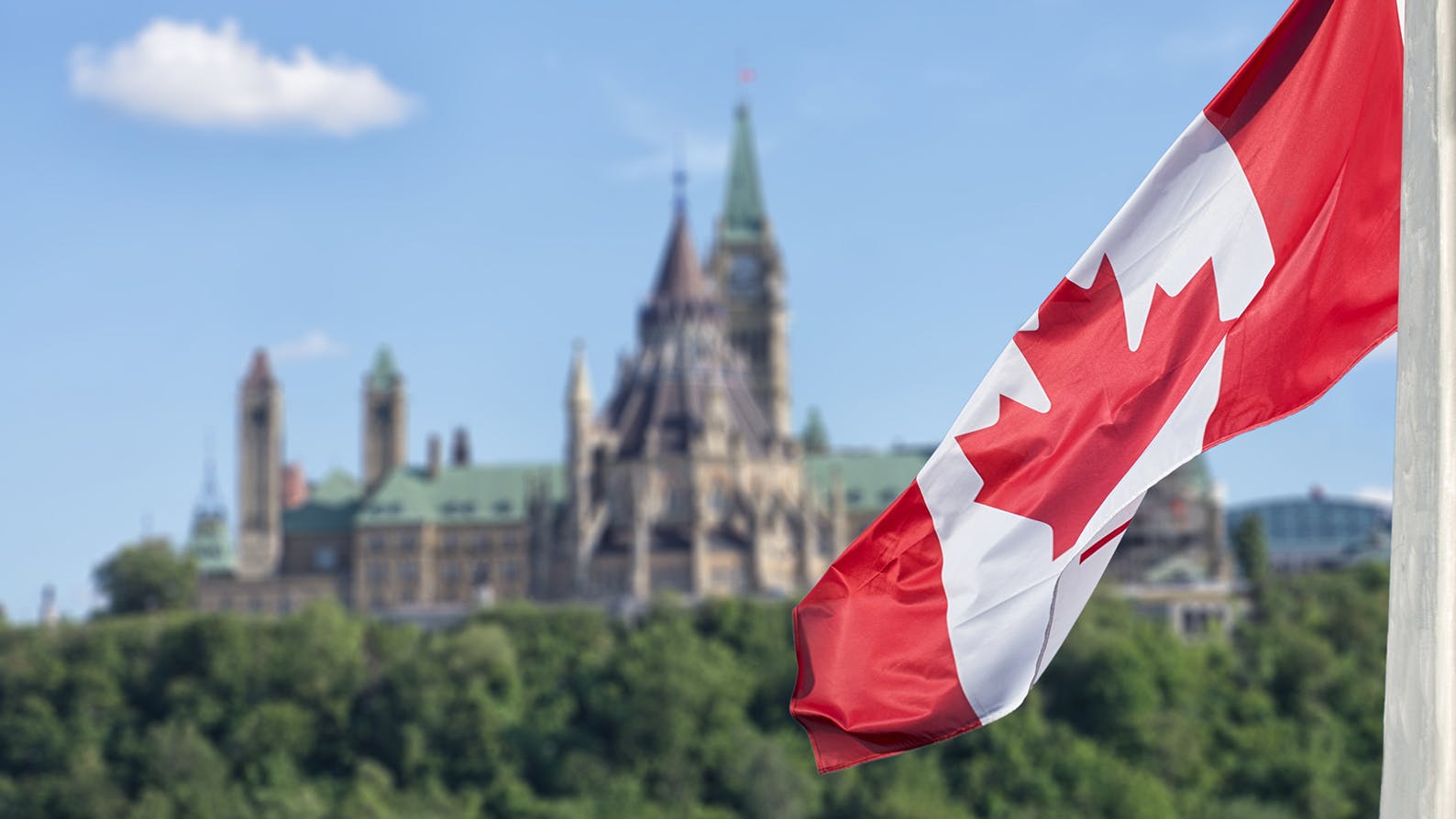 Canadian flag waving in front of parliament in Ottawa