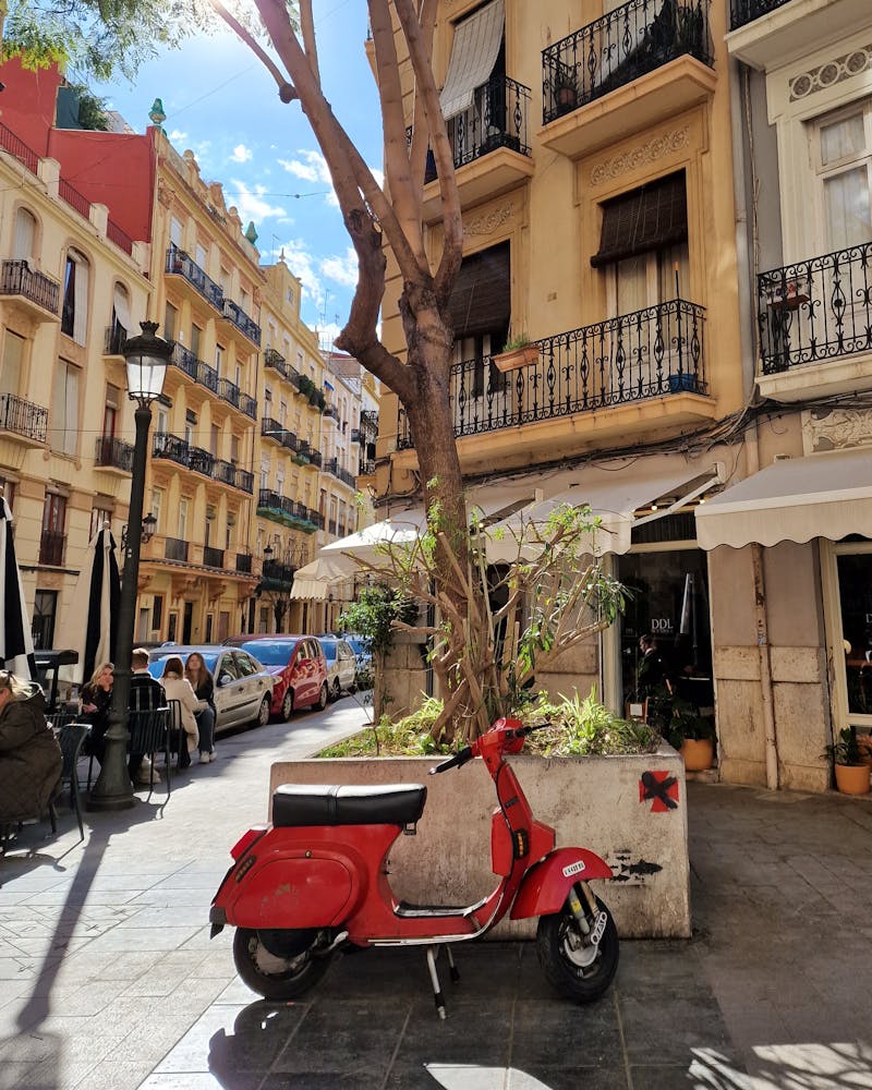 Una vespa aparcada enfrente de un café hipster típico del barrio de Ruzafa de Valencia