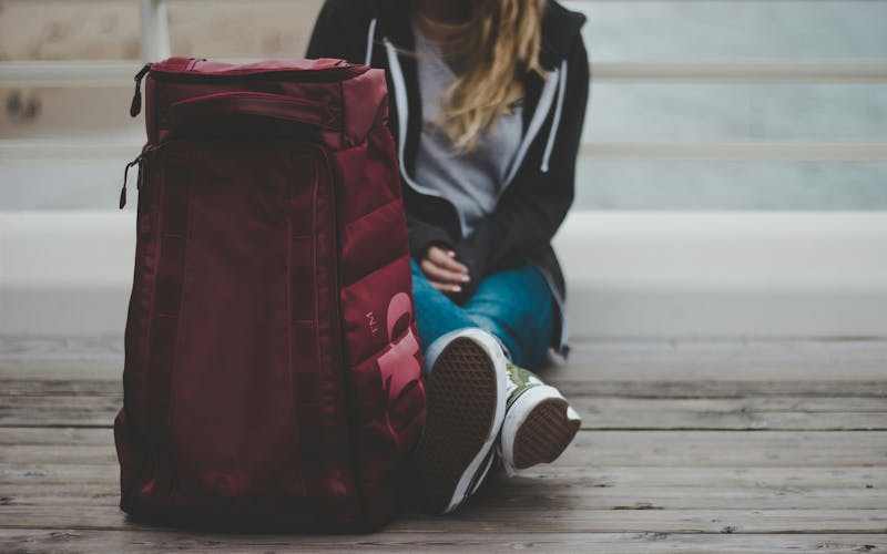 A girl with her suitcase ready to start the trip, sitting at the airport