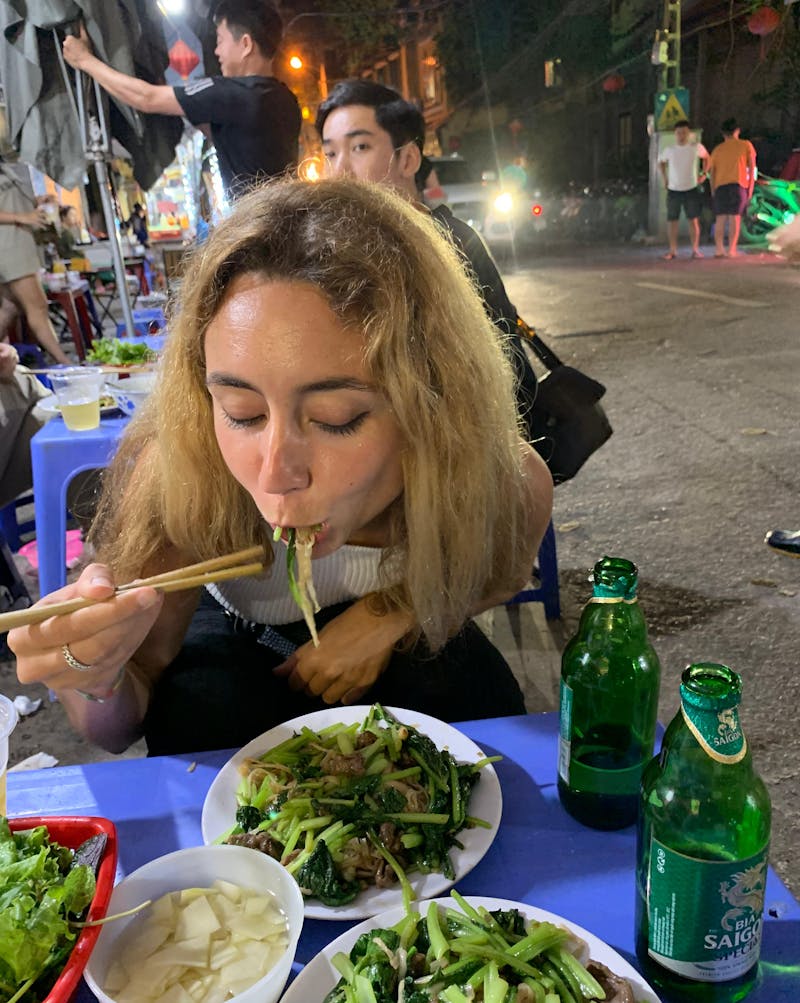 A girl eating typical Vietnamese food on the street